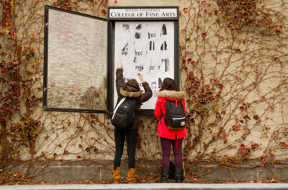  Courtney Schwabe (CFA'14), left, and Julie Ostrow (CFA, COM'14) works together to install Schwabe's World AIDS Day poster in front of CFA November 28, 2012. The two, and their other Junior Design Studio class mates were assigned to design posters fo