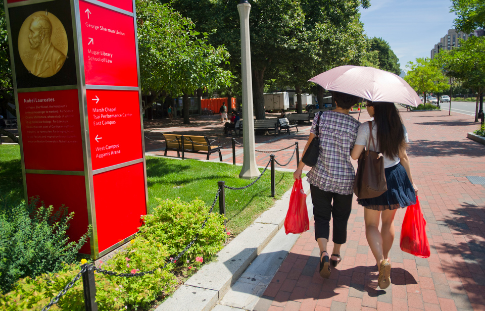  Jingyi Yuan (LAW'12), at right, and her mother Liu Xia of China stroll Comm Ave in some portable shade August 7, 2012. Liu is in town for a visit with her daughter for one month.  Photo by Cydney Scott for Boston University Photography 