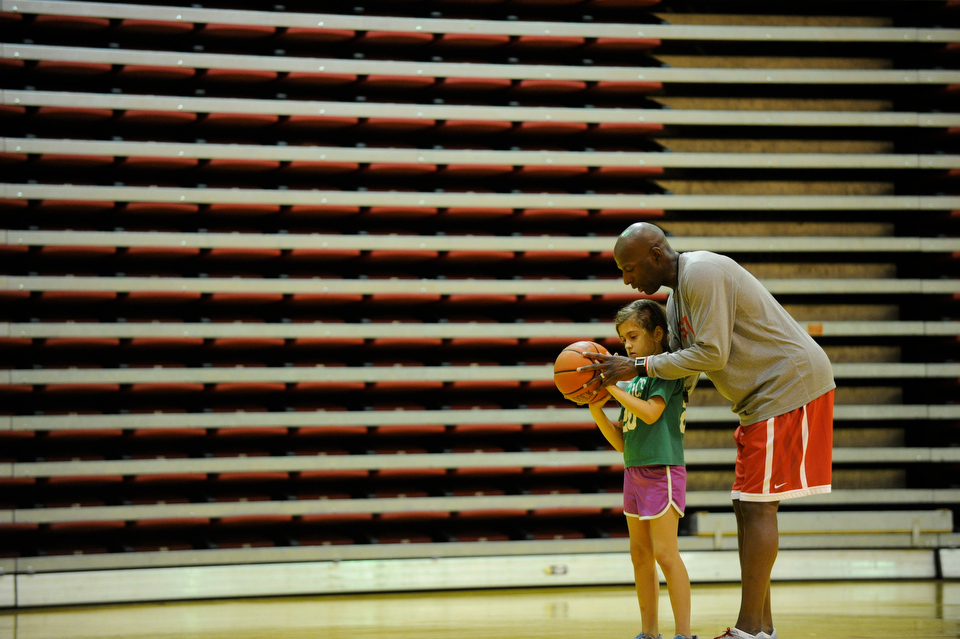  BU Mens Basketball Coach Joe Jones works with his daughter Alicia Gomez, 7, during the Joe Jones Basketball Clinic at Case Gym July 8, 2013. The four day clinic, which runs through Sunday shooting, focuses on ball handling and individual offensive a