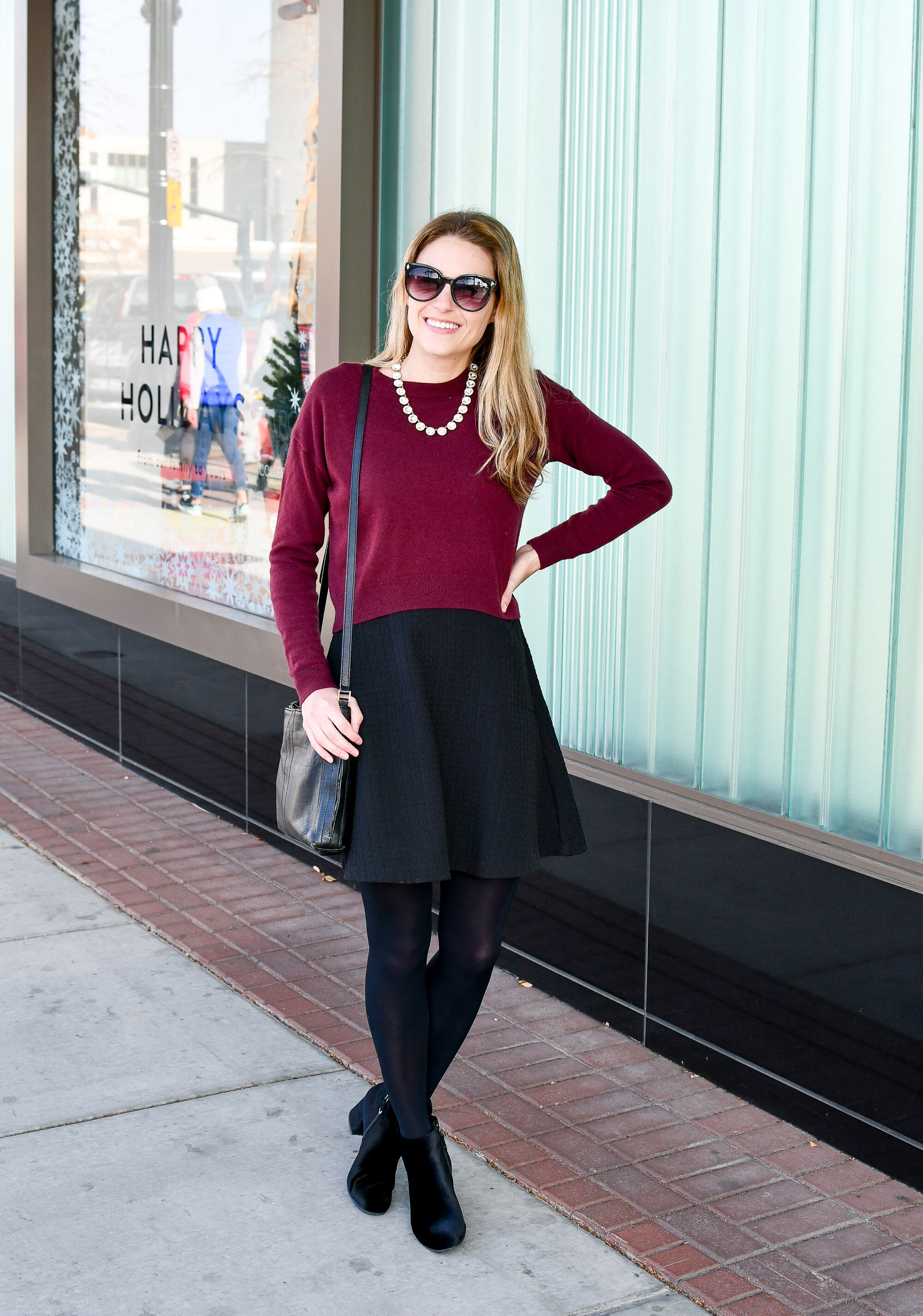 Holiday outfit idea: burgundy cropped sweater over black dress, black velvet ankle boots, crystal statement necklace — Cotton Cashmere Cat Hair