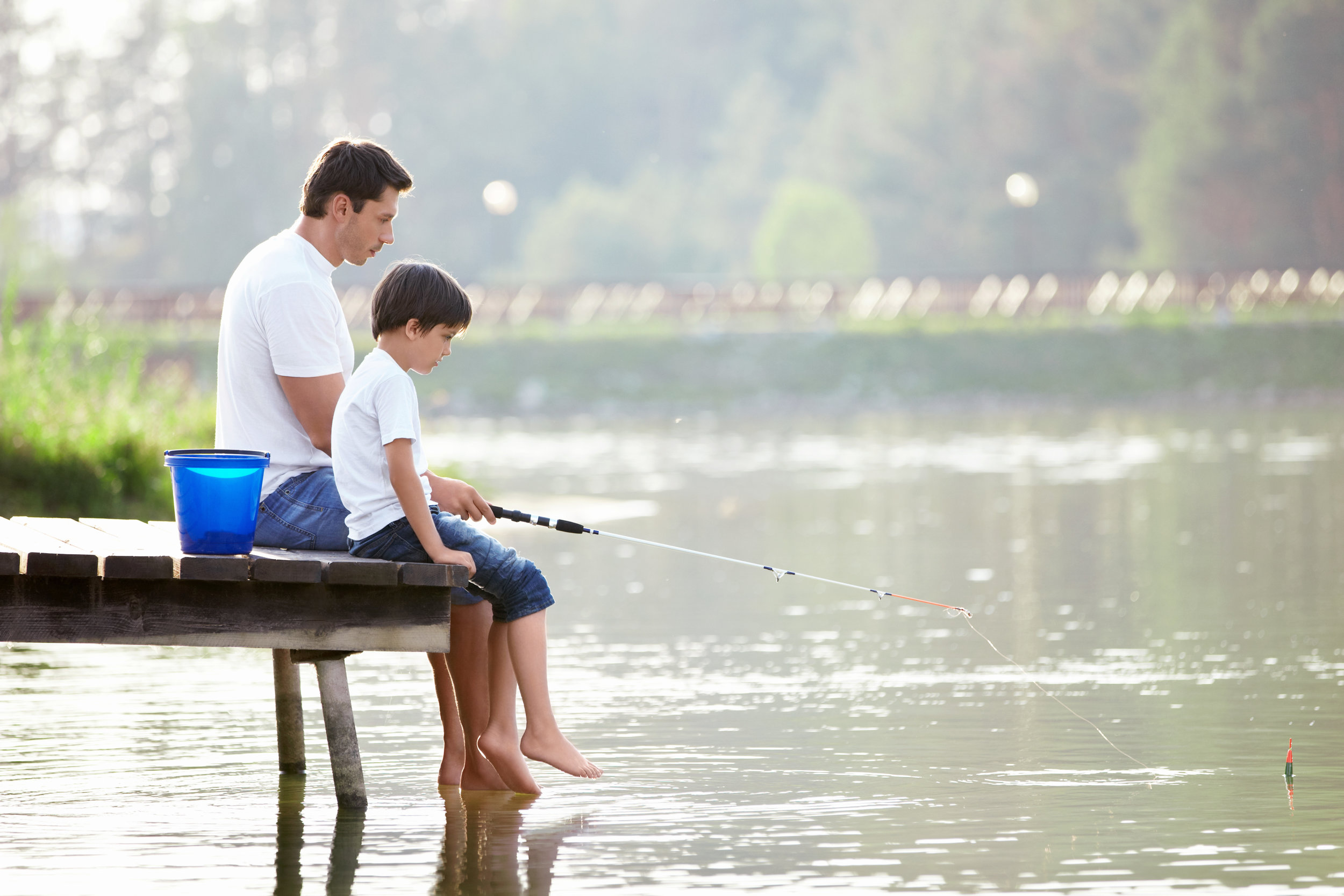 Лов детьми. Идеальная жизнь. Семья у реки. Отец и сын на рыбалке. Семья на озере.