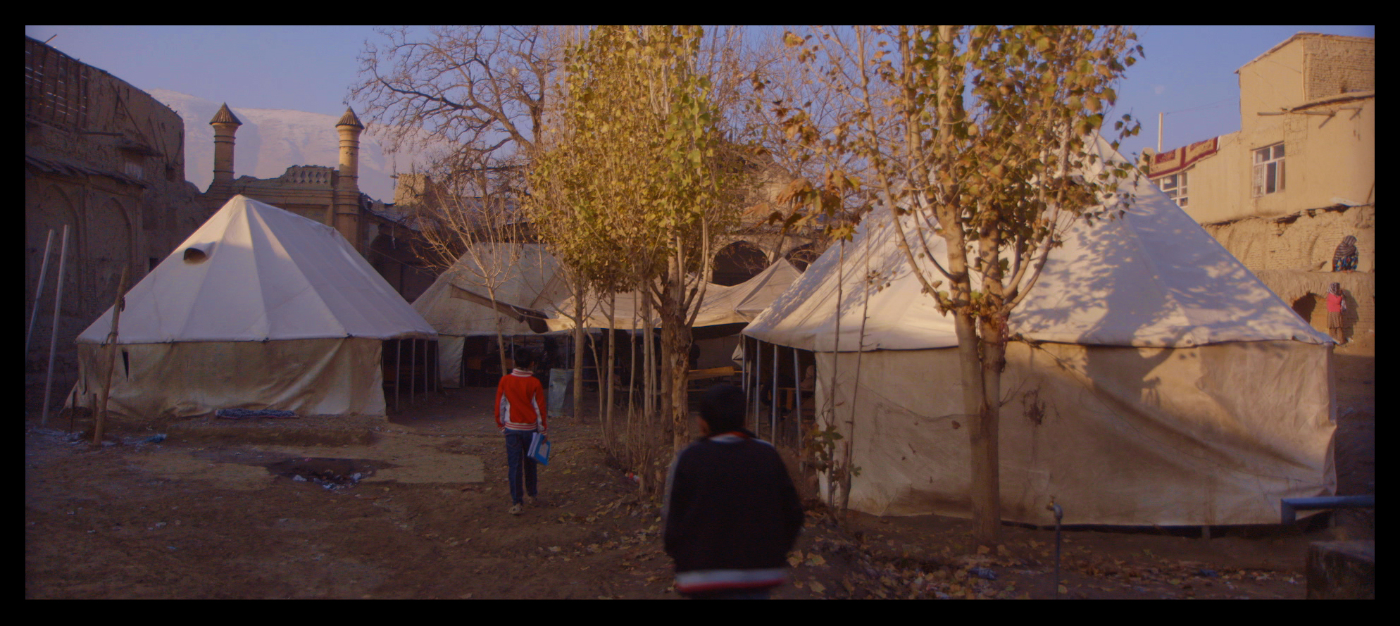 Film still: The Daqiqi Balkhi school as it was when I began filming - tents and benches in the courtyard of a destroyed Kabul mosque