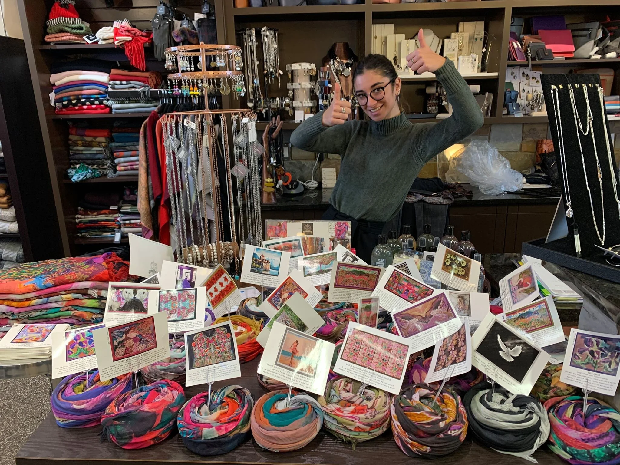 Easiest way when space is limited is to tie the shawls in a “bun” and poke the cards on sticks provided inside each bun! Keep them close to the till and watch them fly our of the door!