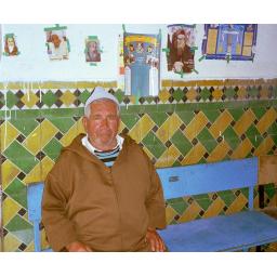 Hananiyah Elfassie, the last Jew in the Ourika Valley of Morocco's High Atlas mountains, guards the tomb of a "Tzadik" who died 500 years ago. Foreign pilgrims visiting the Tzadik's tomb taped snapshots of famous rabbis to the wall behind him.