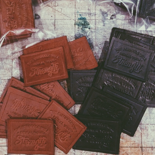 Hand-made leather labels after the dying process. Photo by Rick Bloomer