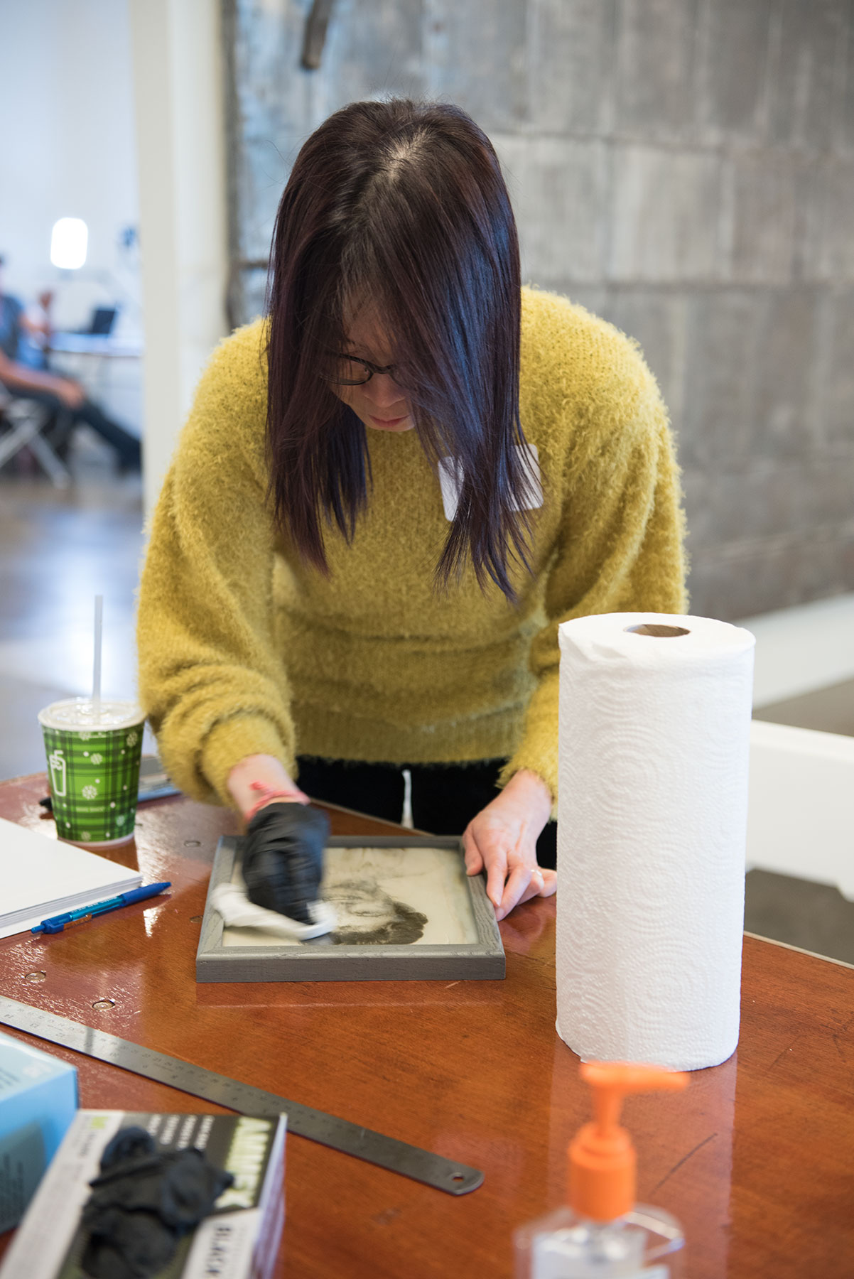 Angel Kan cleans a framed photo prior to copying. / photo by Jim Parsons