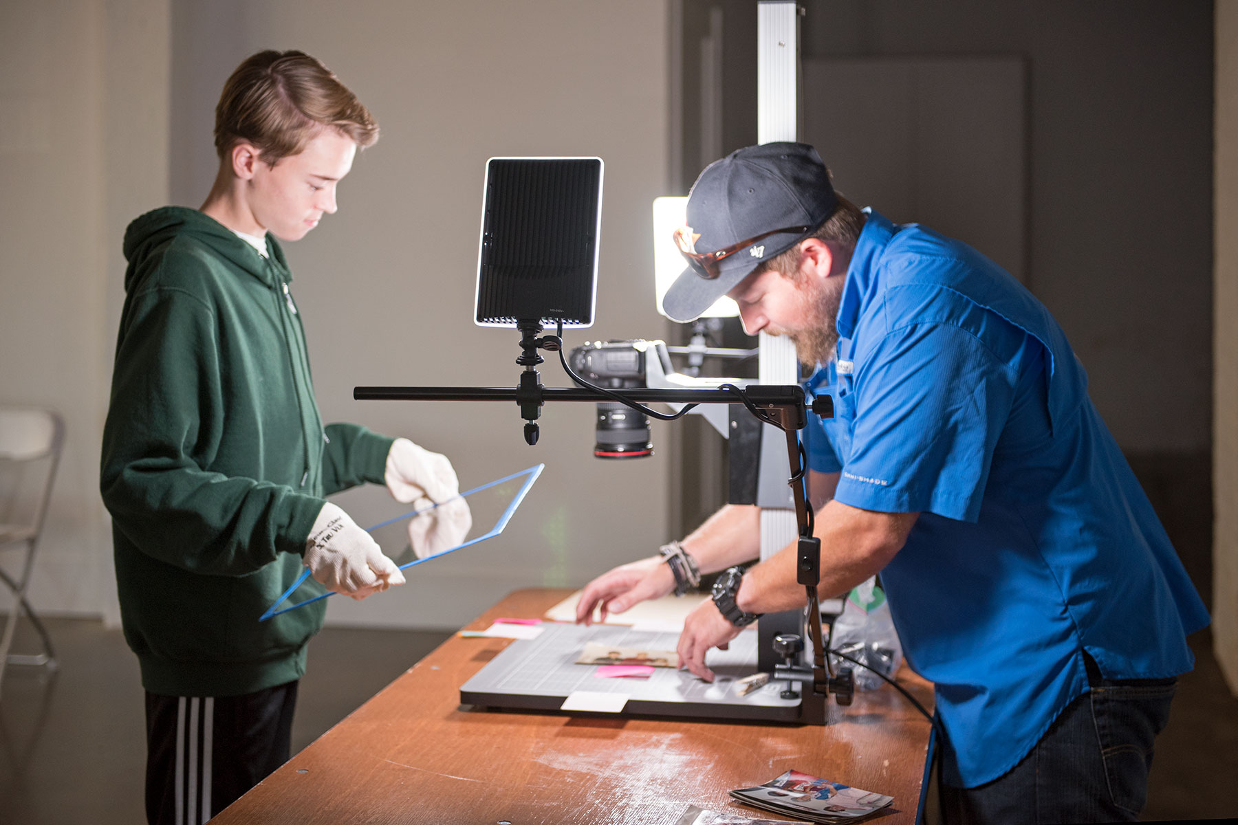 Mychal Warren helps photographer Matt Taras prepare a photo for copying. / photo by Jim Parsons