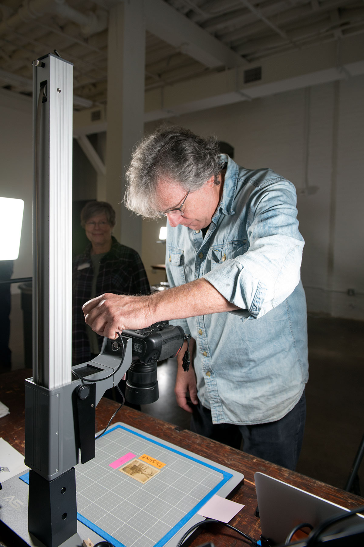  Photographer Nash Baker copies a damaged photo. /  photo by Jim Parsons  