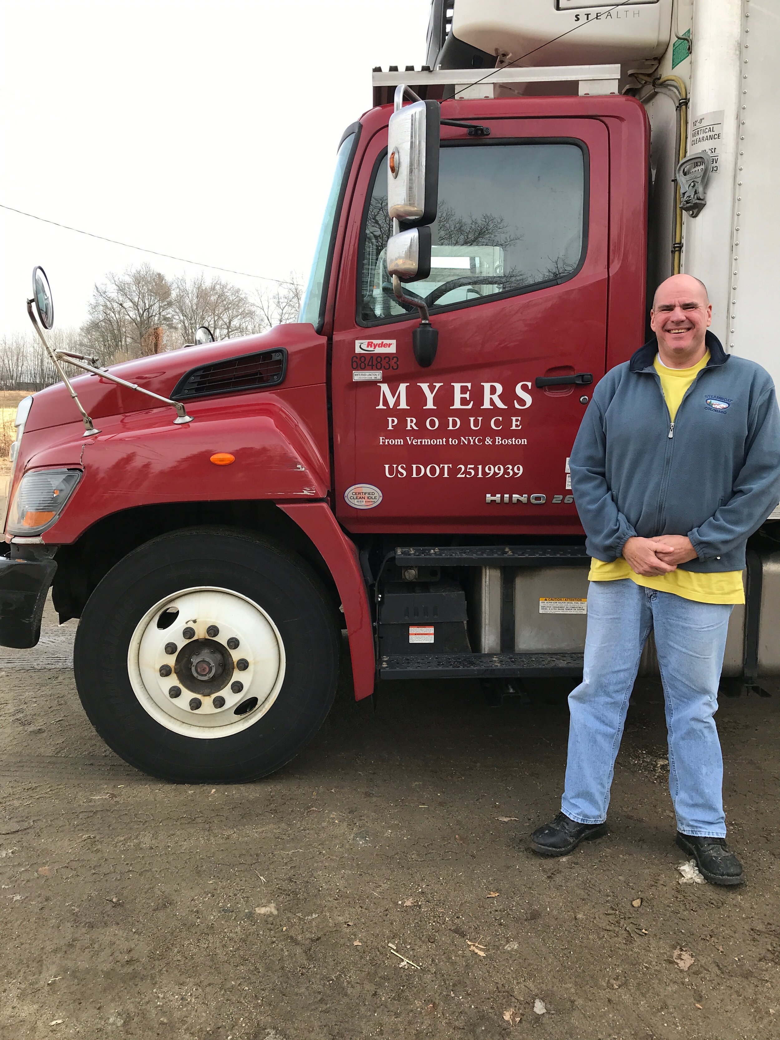 Person standing next to a Myers Produce box truck. 