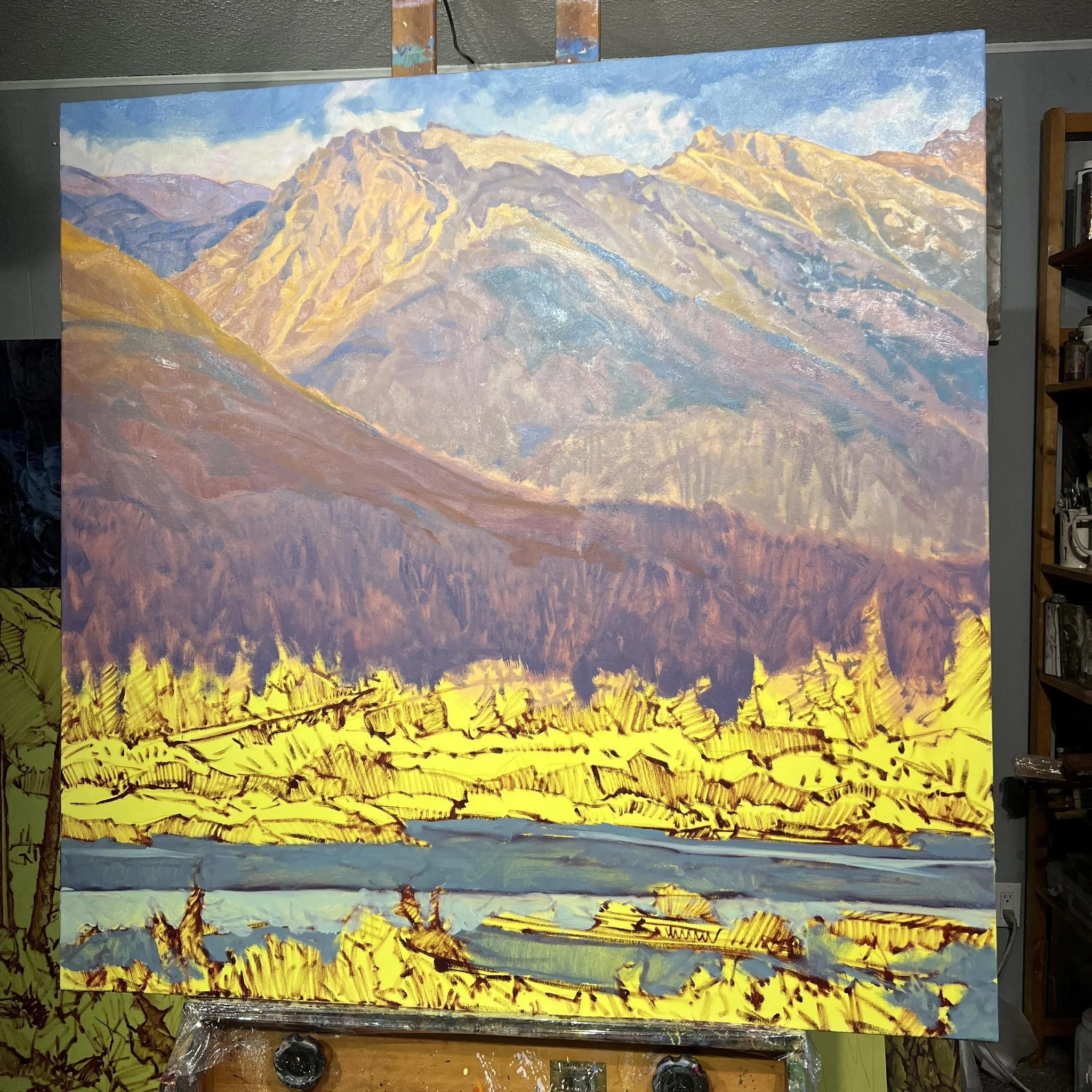 Landscape painting of mountains, a river, and trees with yellow foliage, created with bold brushstrokes and vibrant colors.