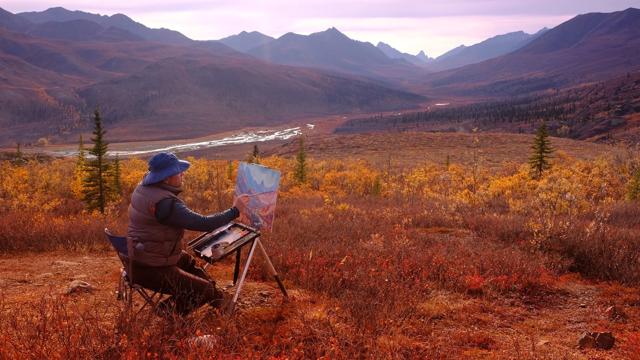"Canadian landscape artist Dominik Modlinski painting en plein air in a remote mountain wilderness, capturing firsthand inspiration for his original oil paintings of the Canadian Rockies and other wild landscapes."