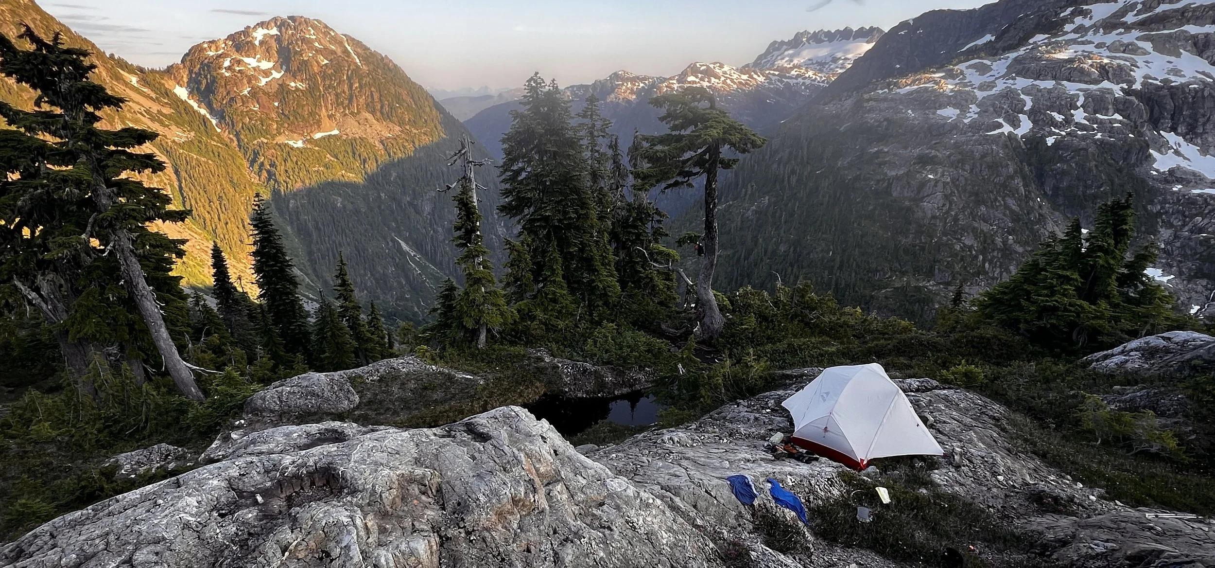 Camping in Strathcona Provincial Park at sunrise, with morning light spilling over mountain valleys on Vancouver Island.