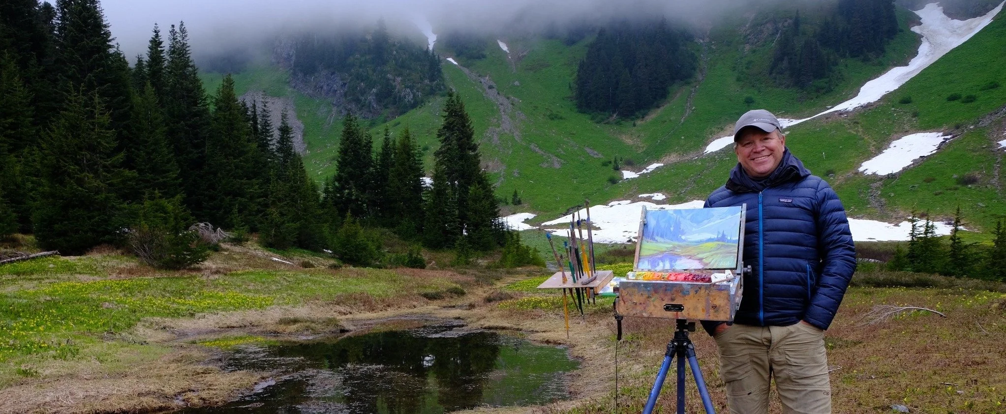 Artist Dominik Modlinski painting en plein air in the Cascade Mountains, capturing rugged alpine landscapes.