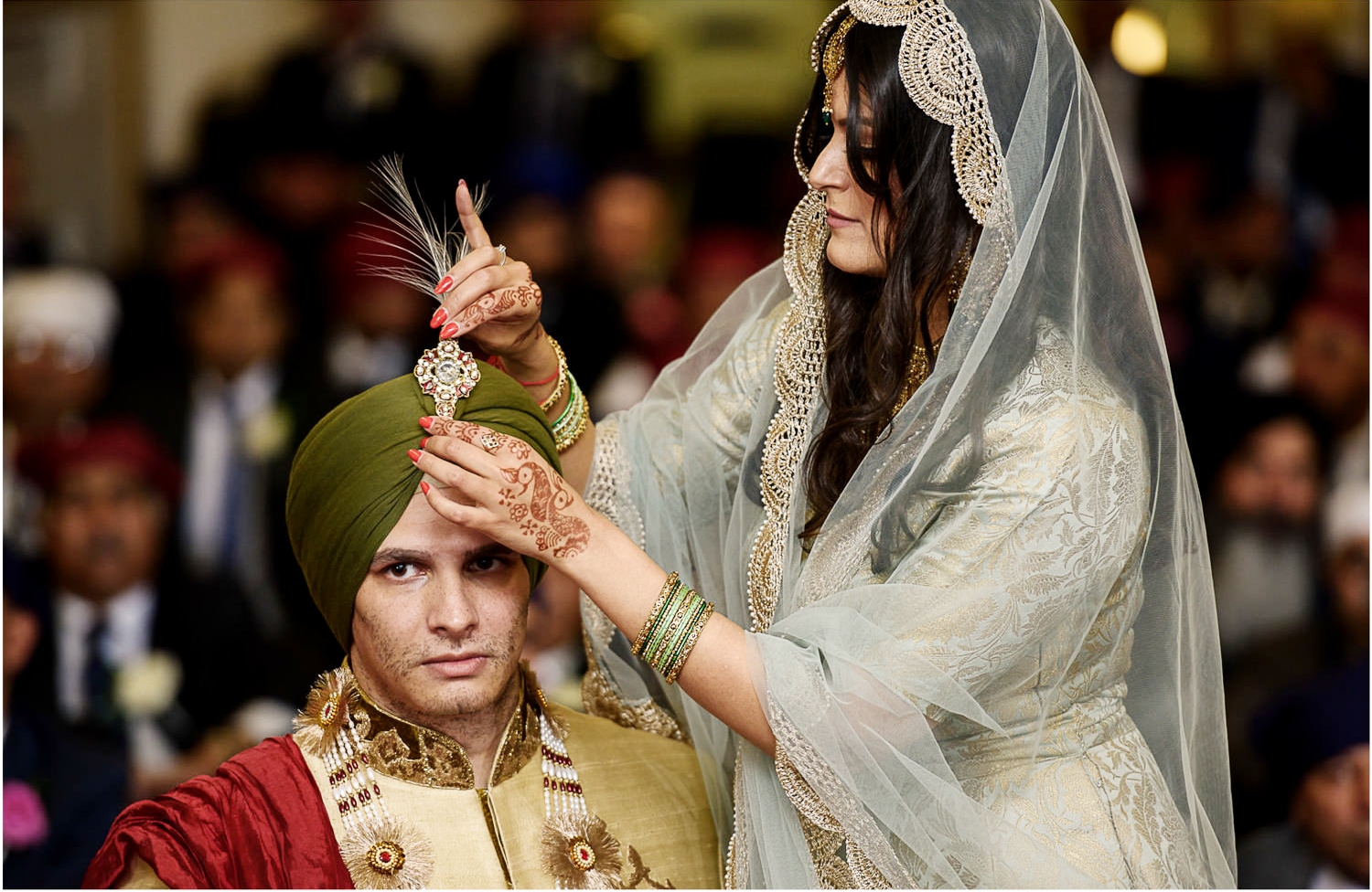 Sister of Sikh groom adjusting his turban