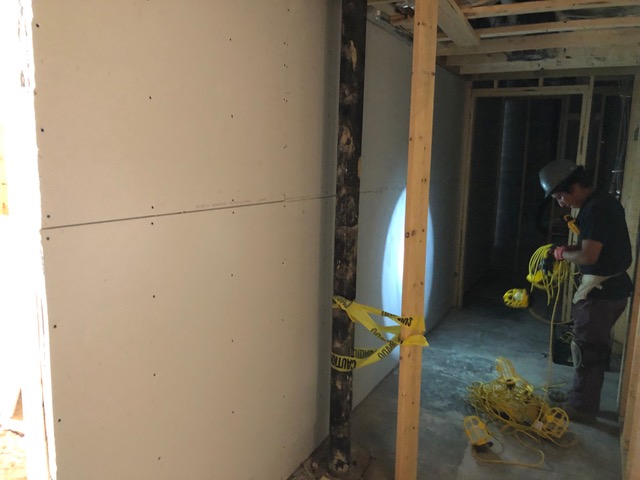Sheetrock being put in the bathroom hallway.