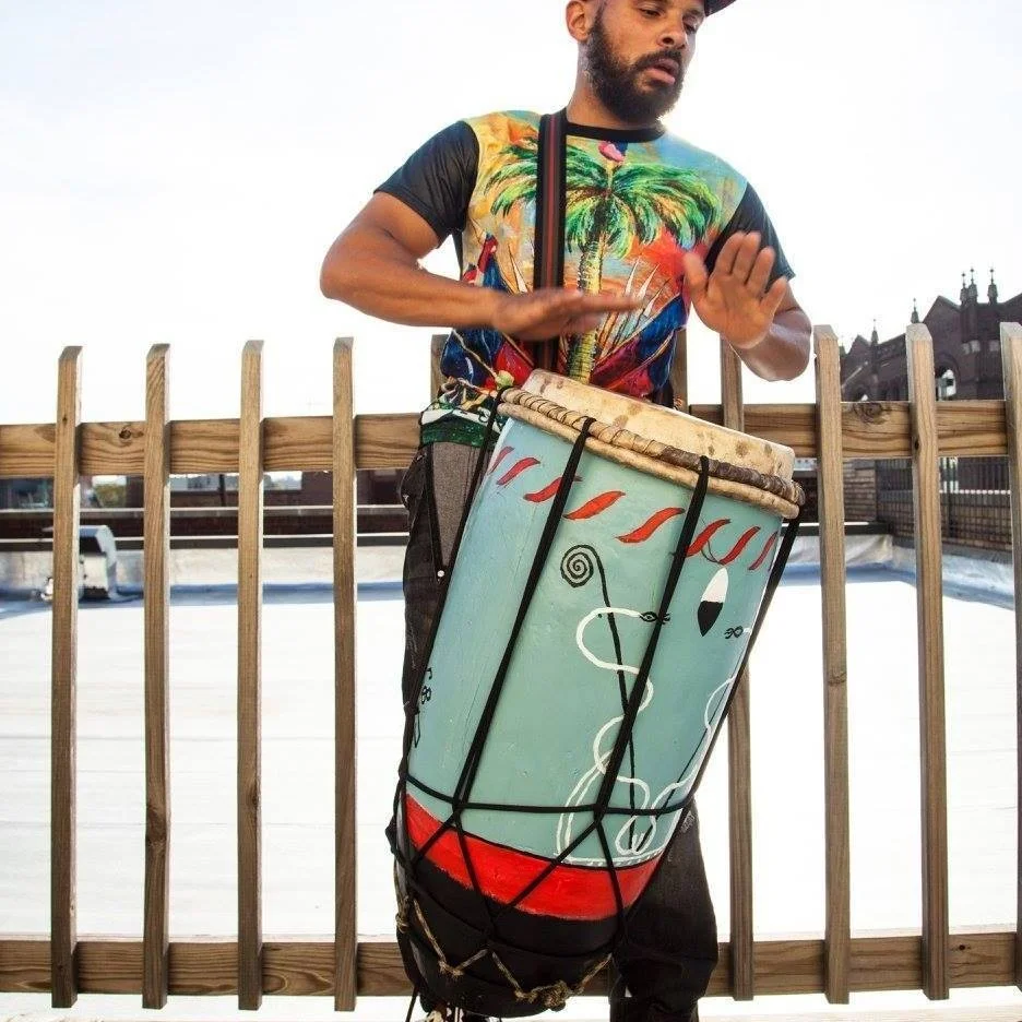 Okai is a vocalist/percussionist who embodies the music of the African Diaspora. Brooklyn born with Haitian descent, young Okai was beating on anything that he could get his hands on to help his imagination grow. His ears became infected with the hard boom bap drum loops of Hip Hop and Roots music from the Caribbean. These sounds led him on a musical path to find Rock, Jazz, Samba, Salsa, Rumba and pretty much anything that involves percussion. Okai began his path of percussion on the drumset playing for various churches. He then played congas for his high school band for several years. Once he was introduced to the West African djembe, he concentrated on that for more than 10 years. Aside from being an achieved percussionist, Okai is also an achieved emcee that has worked with various artists and has a couple of solo albums "Dekonstruktion of the Mind" and "Okai's Odyssey". Okai's cultural background shaped him into being the full rounded artist he is today. He is currently the lead singer and percussionist of Brown Rice Family who won the 2012 “The Battle of the Boroughs” in NYC. Okai is also co-founder of Strings N Skins who are currently finishing an album to be released summer 2019. He is an active percussionist in New York always sharing his voice and energetic rhythms. Okai has had the pleasure of performing before audiences at Brooklyn Museum, the legendary African art auction exhibition at Sotheby's, Madison Square Garden, Carnegie Hall and venues throughout the United States. Internationally Cuba, Haiti, Puerto Rico, Canada, Tanzania, Ivory Coast, Australia, Japan and Brazil have been showered with his sounds and soon the rest of the world will.