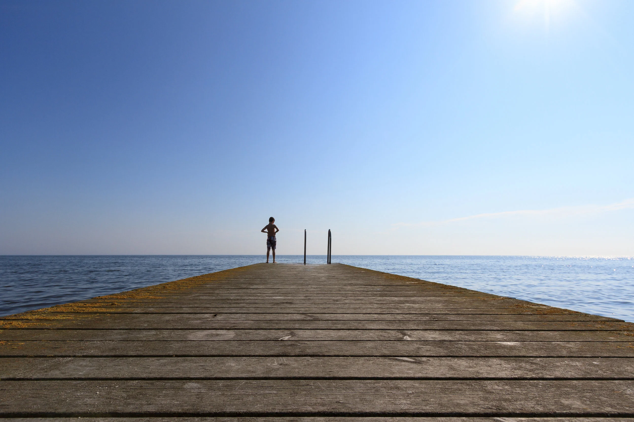 Lonely-boy-on-jetty-taking-a-summer-bath-936626888_3869x2579.jpeg