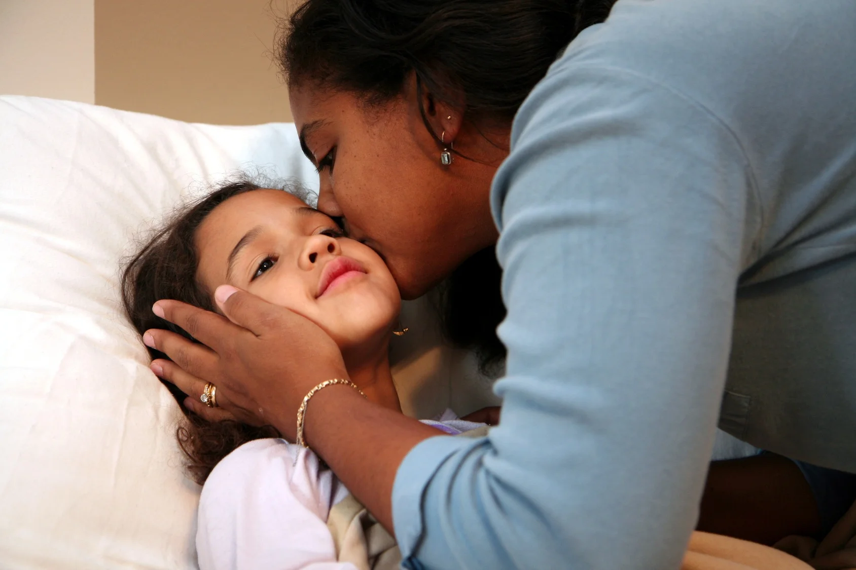 Mother tucking in daughter._6329344_M.jpg