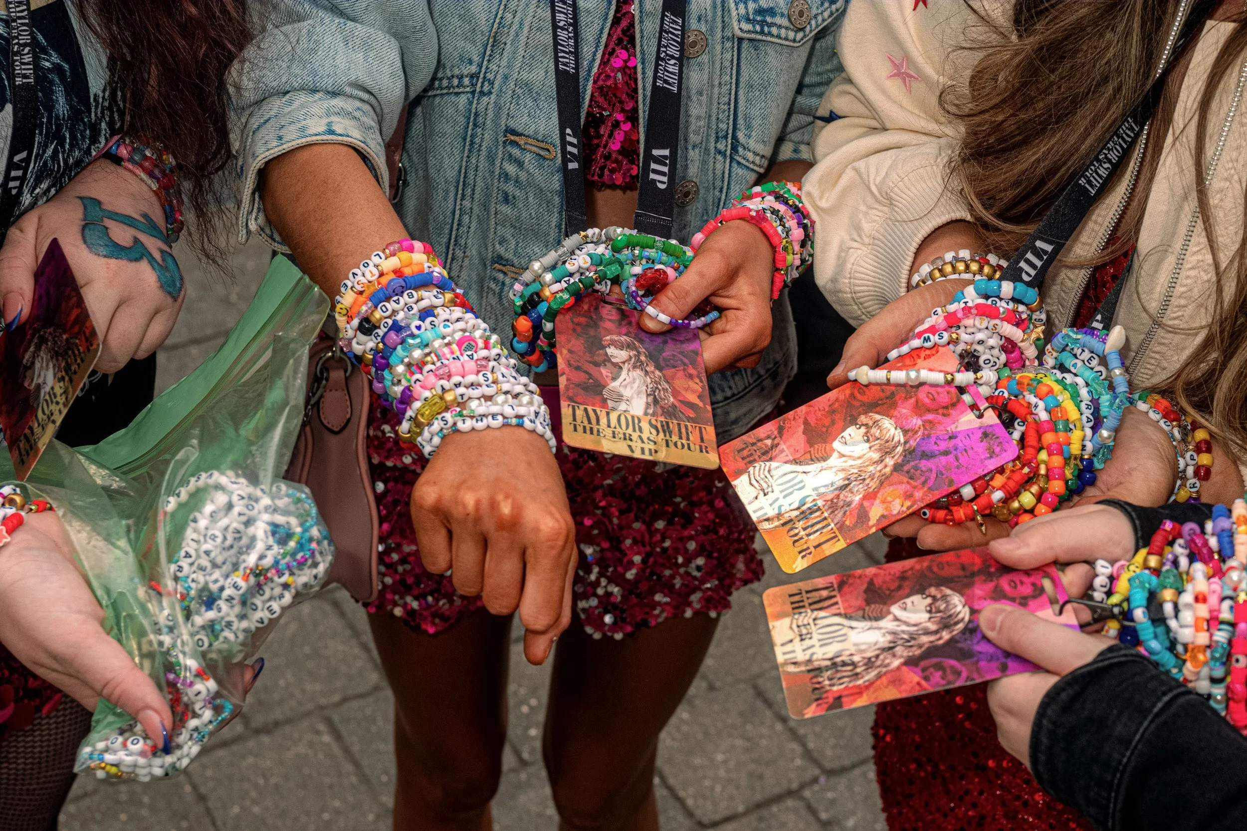 Taylor Swift fans show their colourful friendship bracelets and Eras Tour lanyards together.