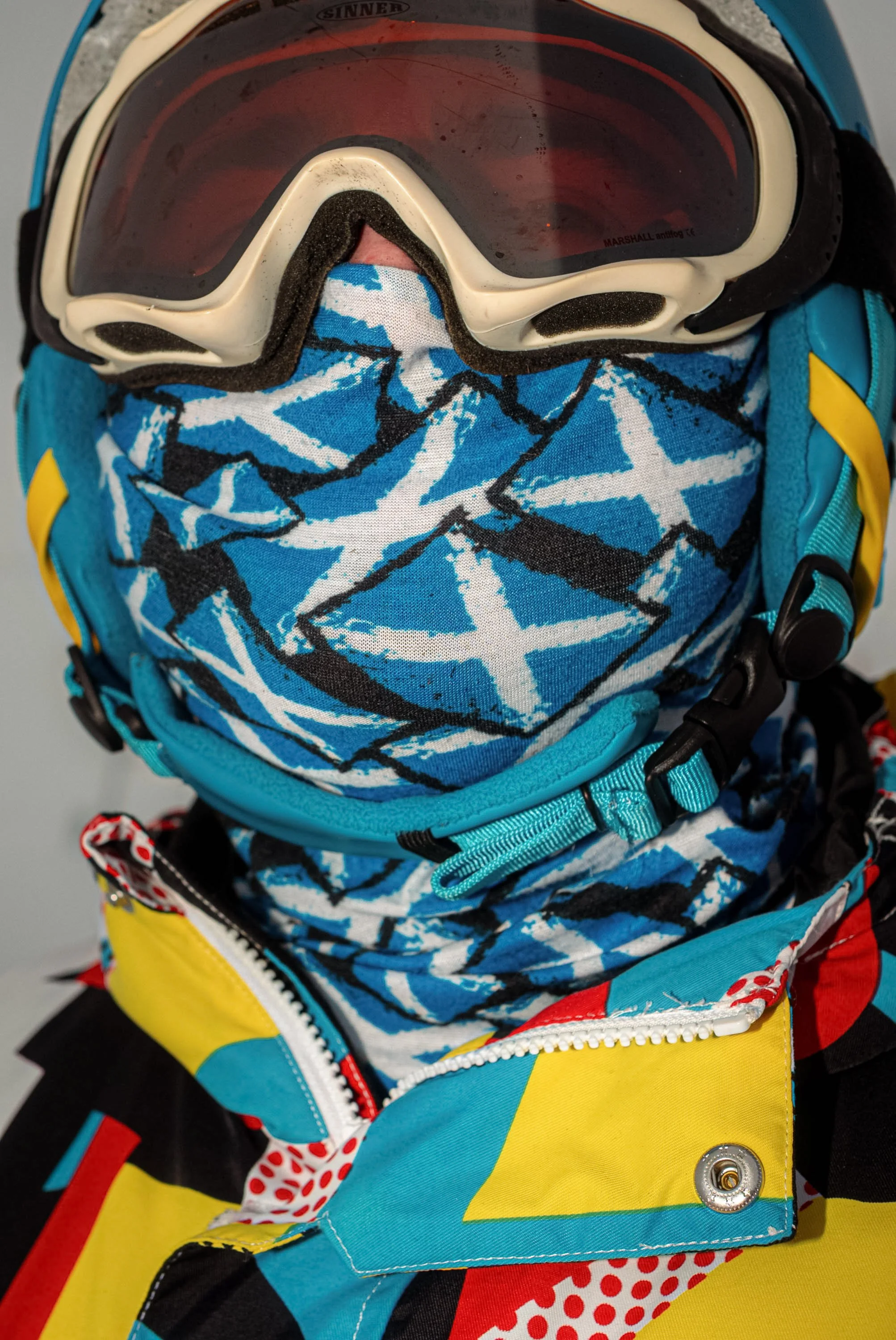 Close-up of a skier wearing goggles and a patterned blue face covering, from Weather Permitting.