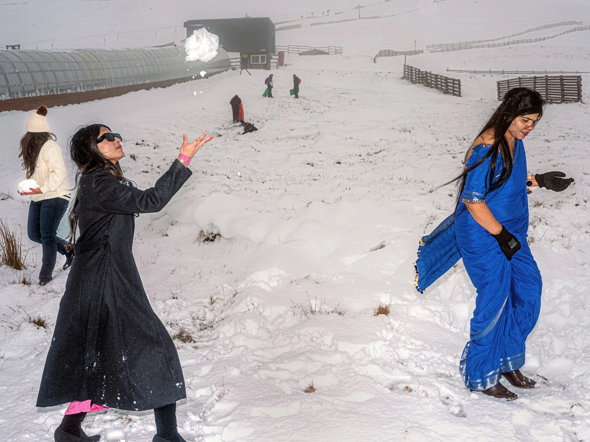Visitors in long dark and bright blue outfits play in the snow, from Weather Permitting.