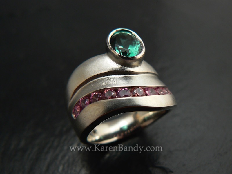 Custom made, one-of-a-kind ring with natural color, fair trade padparadscha sapphires and a mint green tourmaline in 14k white gold. Bead-blast finish. 