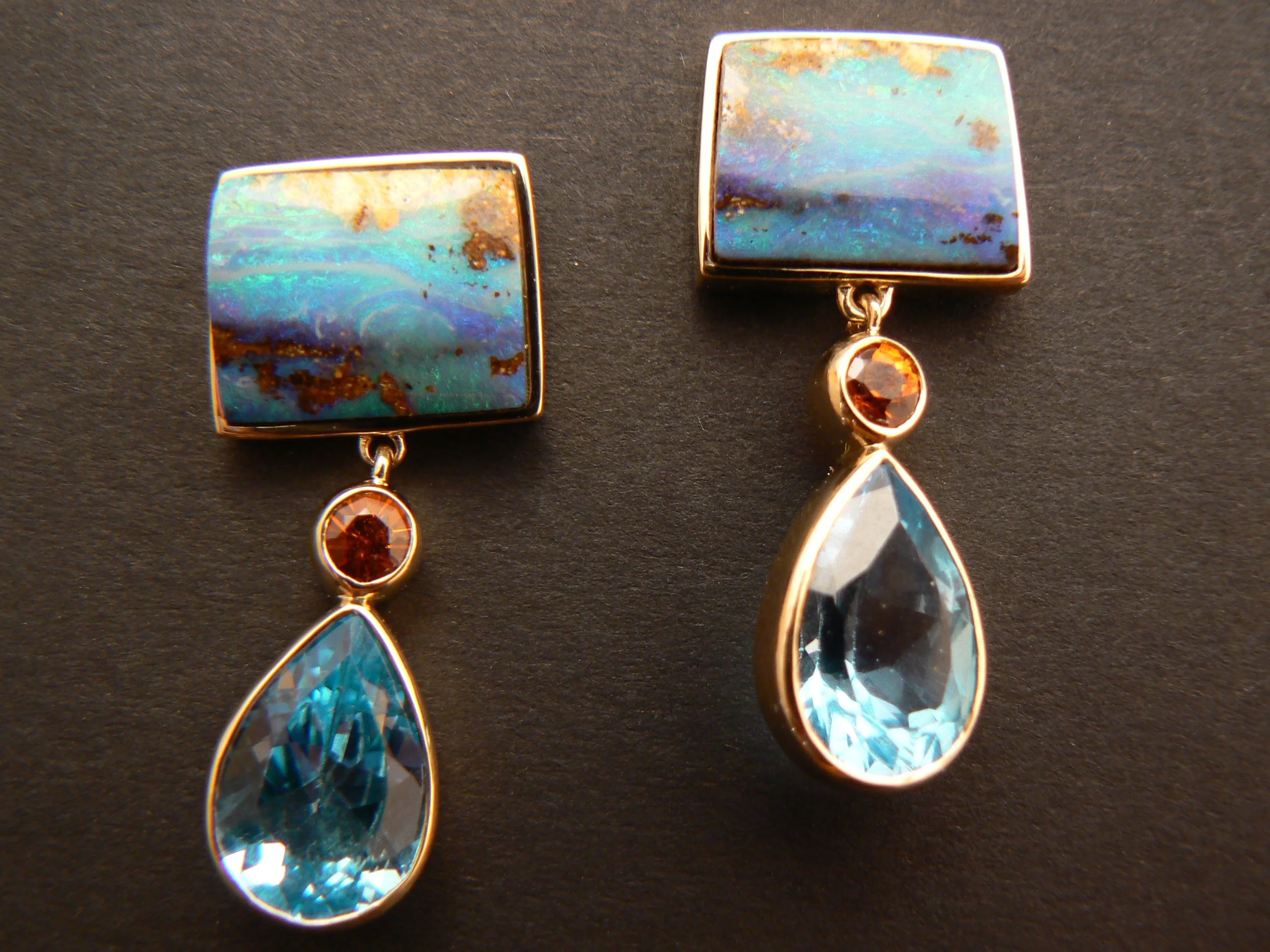 Here's an example of the client having unset blue topaz drops and wanting to pair them with something. She fell in love with these boulder opals that I had in the safe. We also found the perfect accent color in my stash of gems. The inspiration for the earrings was born that day.