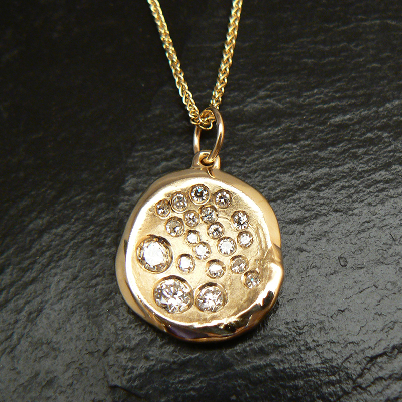 The family rings made into a custom pendant reusing the gold and diamonds.