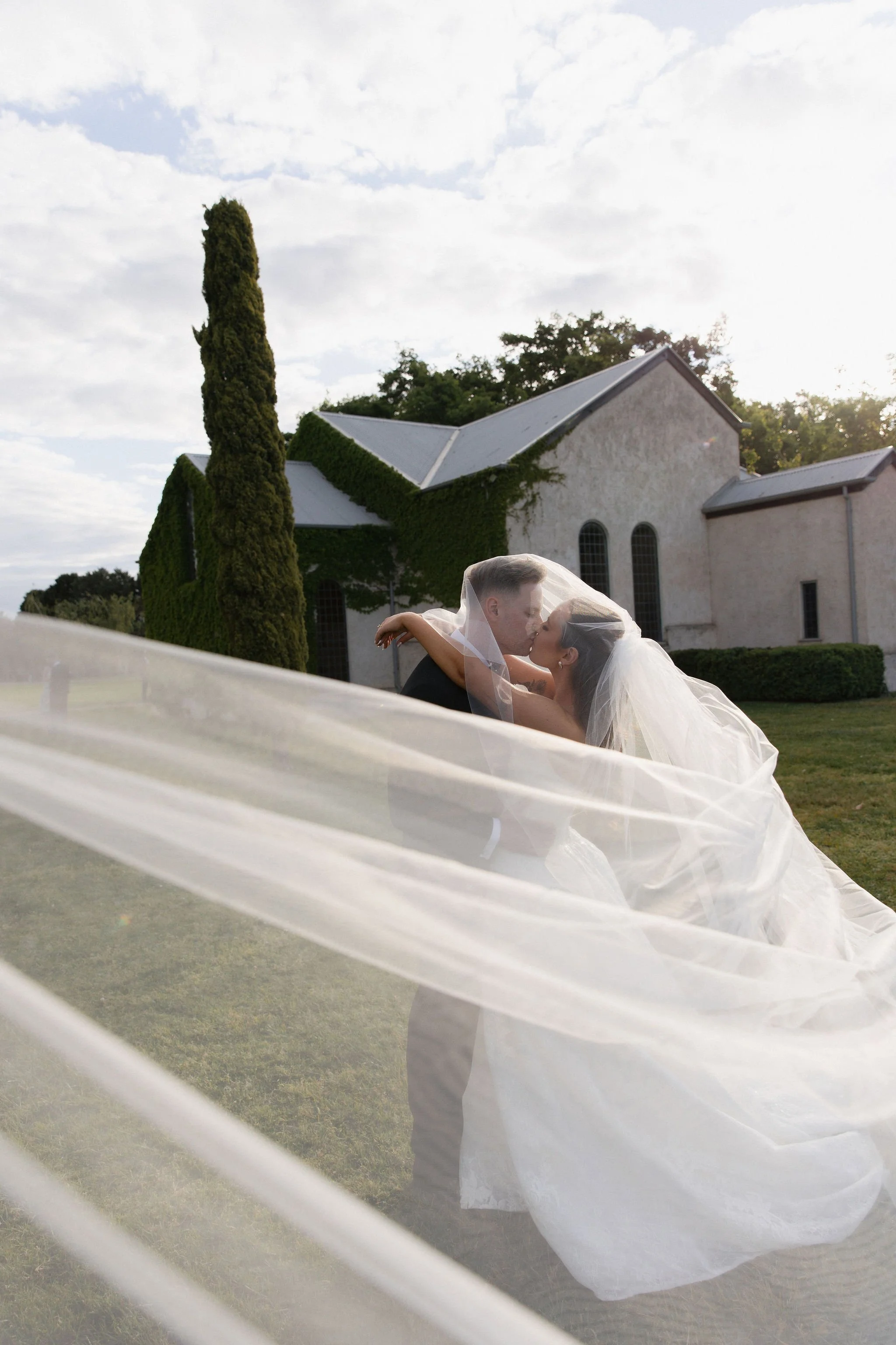 Pippa and Josh kissing outside The Chapel at Stones of the Yarra Valley, photographed by Ten Acres Agency.