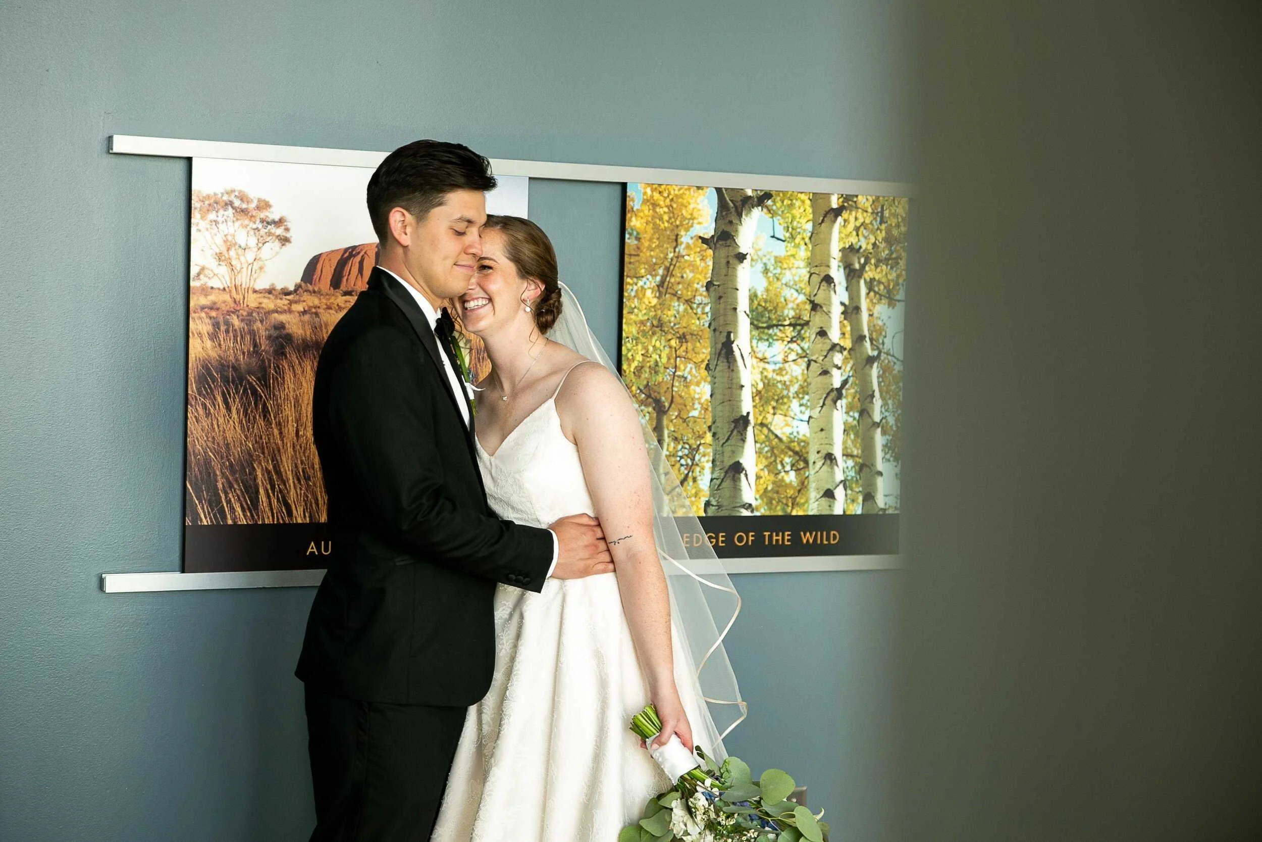Couple snuggles up in front of nature photos on the wall