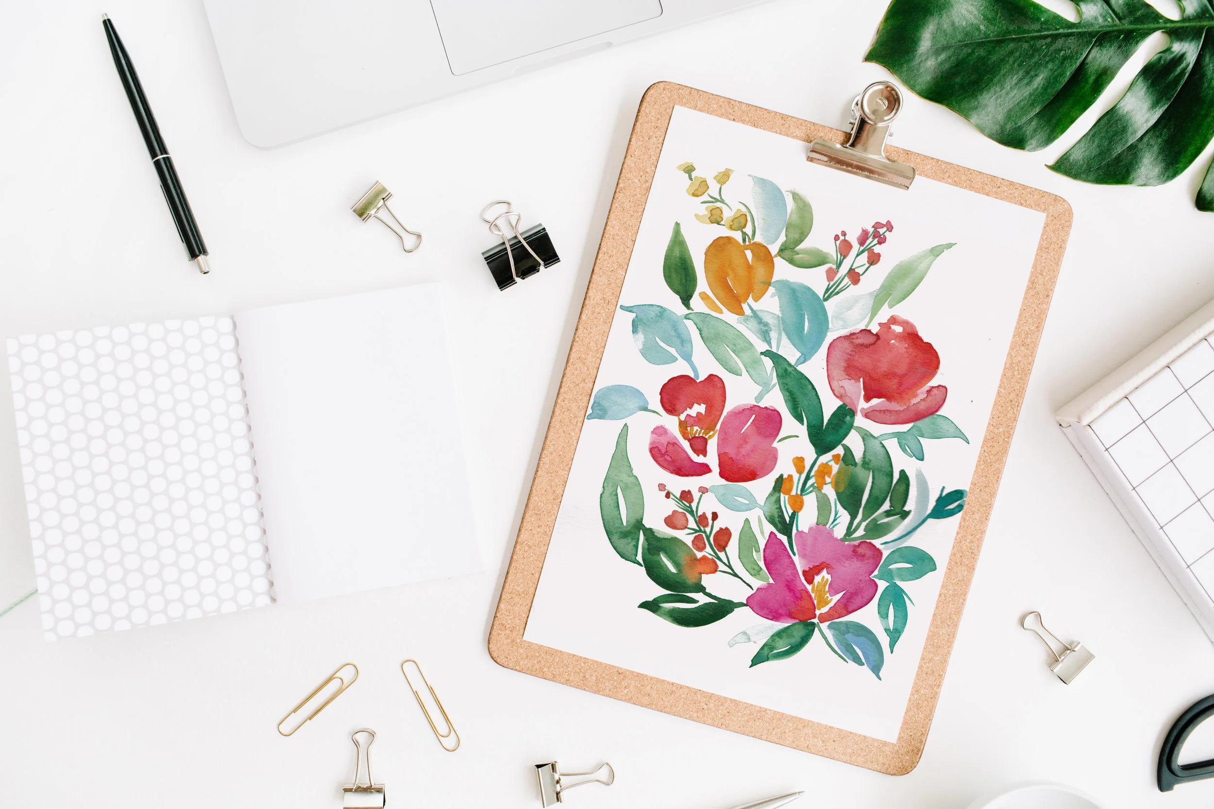  Home office workspace mockup with laptop, clipboard, palm leaf, notebook and accessories. Flat lay, top view 