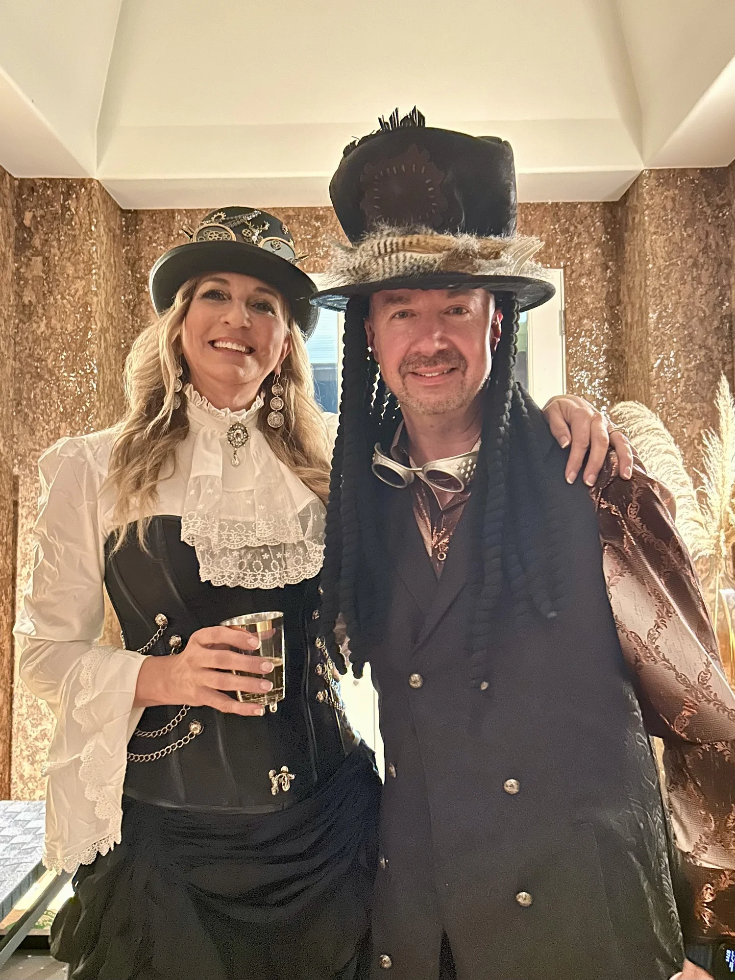 Chuck and Rilla smiling together in elaborate costumes and hats.