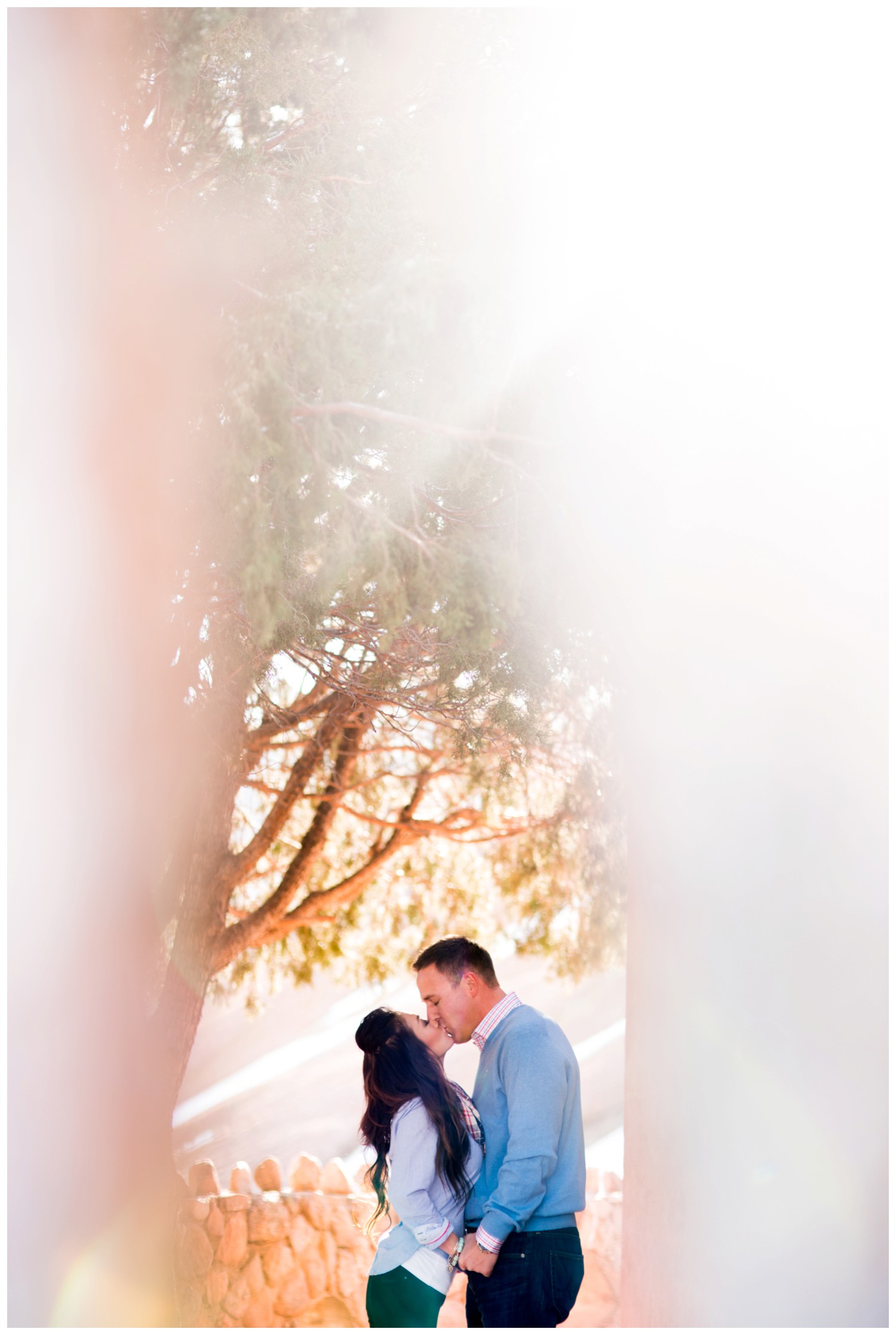 creative engagement photo of couple kissing between trees