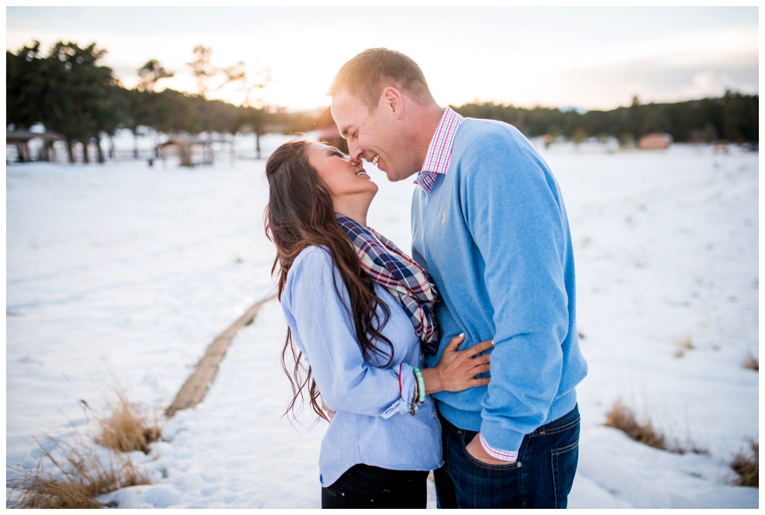 couple kiss in front of mountain sunset