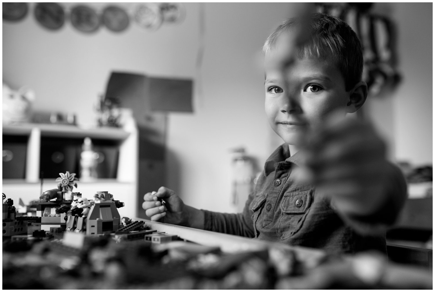 little boy plays legos in room