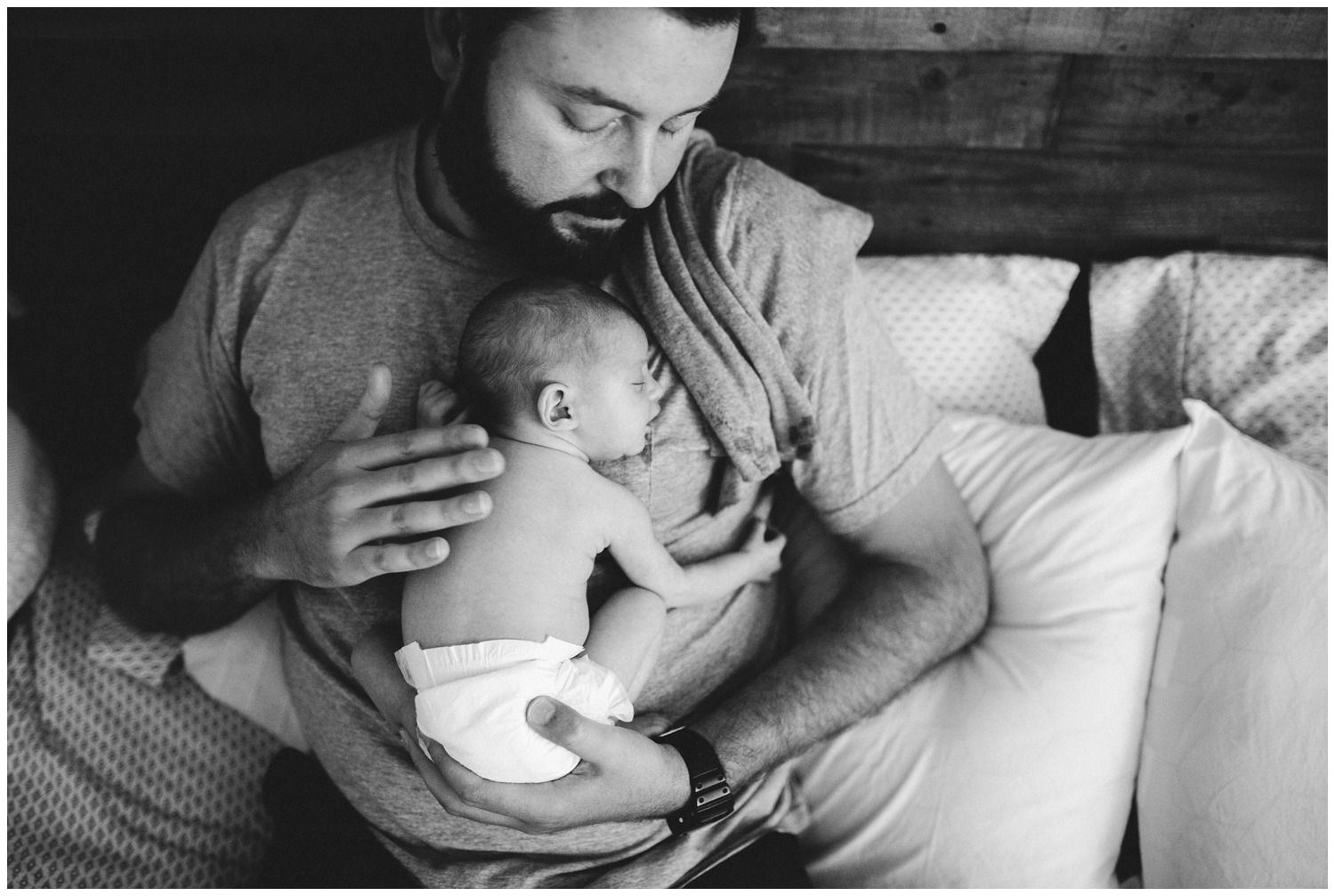 dad holds newborn in home