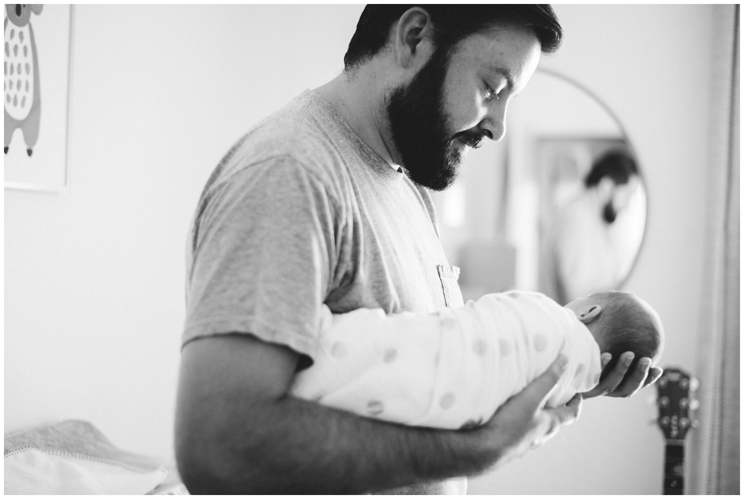 Dad holds newborn in Nursery