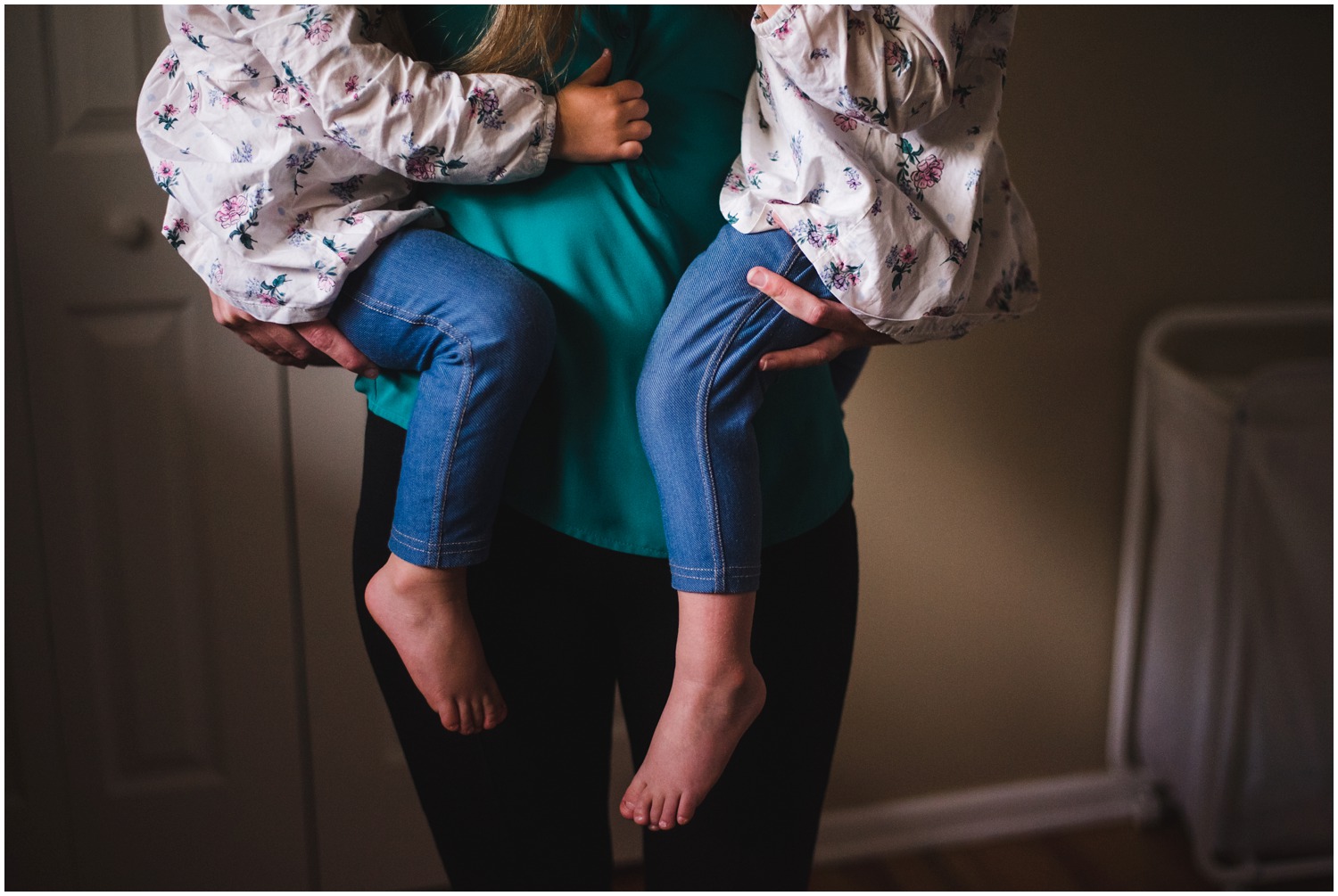 mom holds twin toddlers