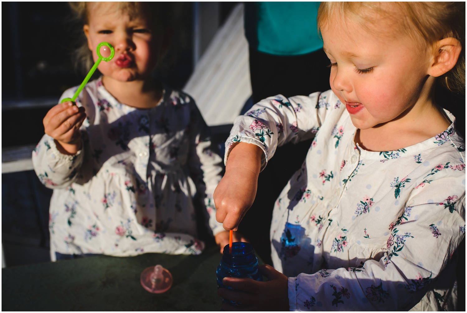 twins blowing bubbles in Colorado backyard