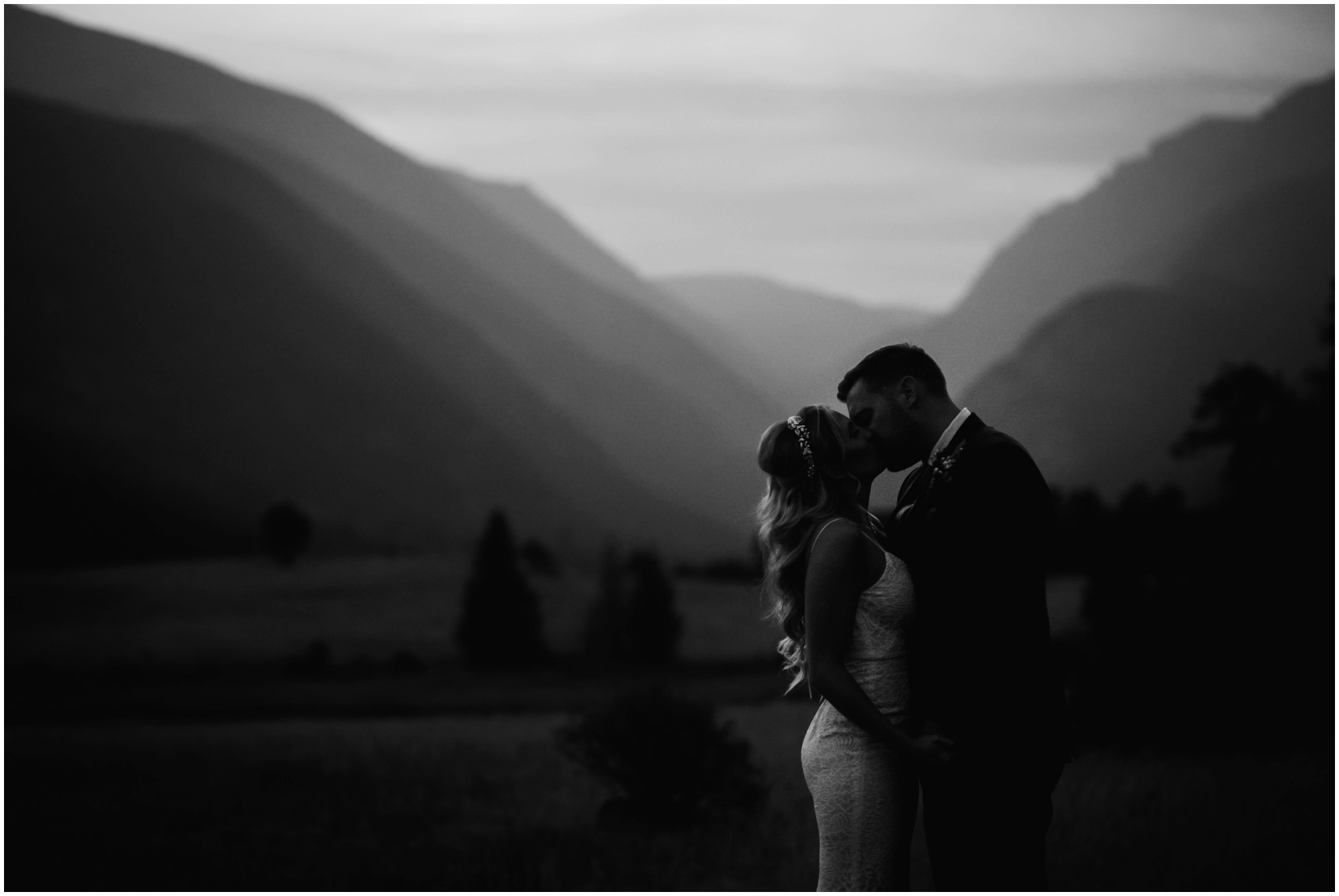 moody black and white photo of bride and groom kissing during colorado twilight
