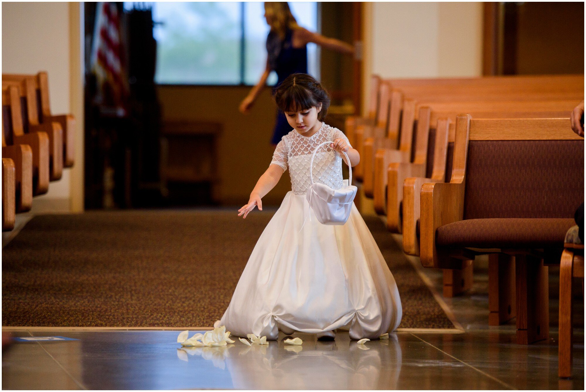 flower girl in beautiful dress walks down the aisle in highlands ranch