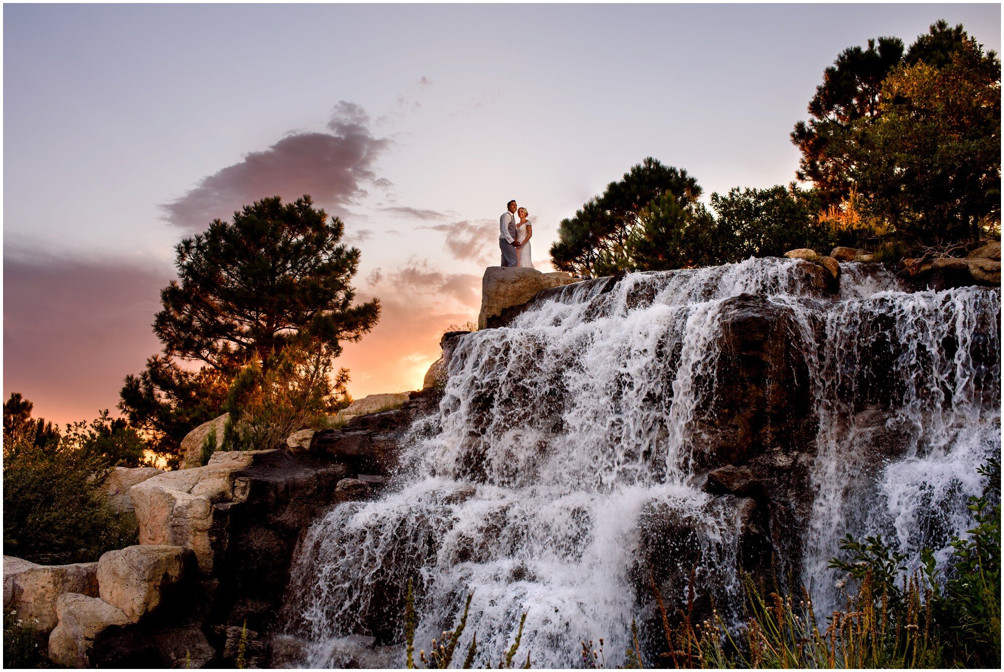 bride and groom on the waterfall at sanctuary golf course