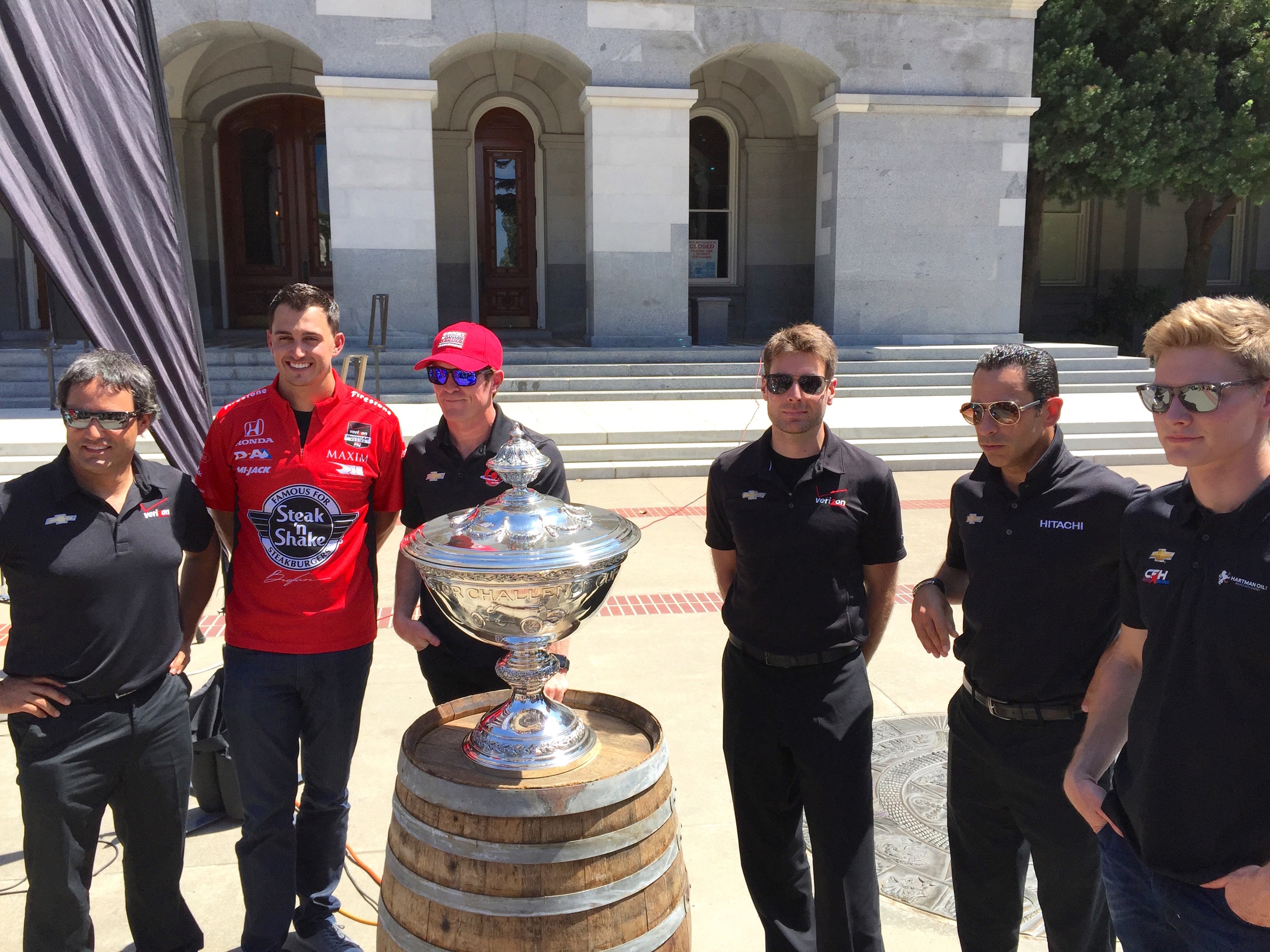 (From Left To Right) Juan Pablo Montoya, Graham Rahal, Scott Dixon, Will Power, Helio Castroneves, and Josef Newgarden stand behind the IndyCar Championship Trophy.