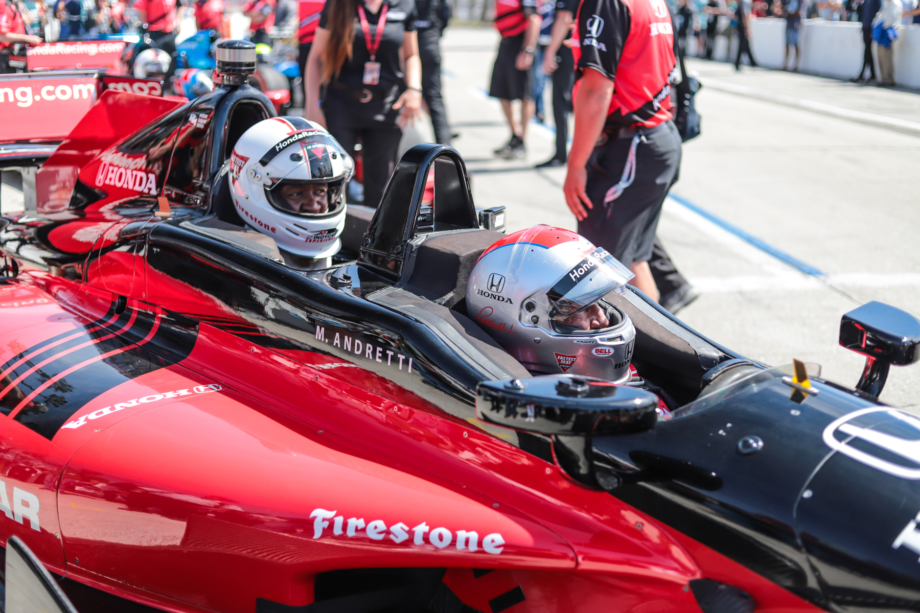 Mario Andretti prepares to take football player Willie McGinest around Long Beach in the IndyCar two-seater.