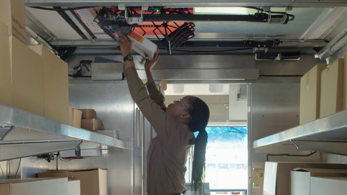 A parcel is loaded into the cage from inside the van.