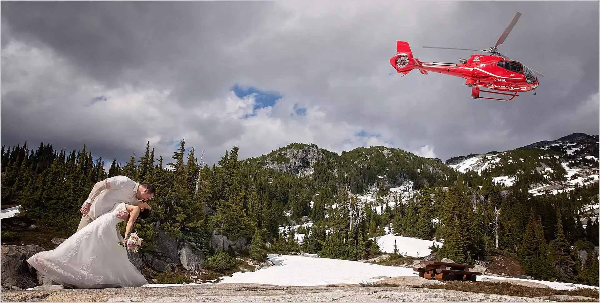 Groom kissing bride under helicopter