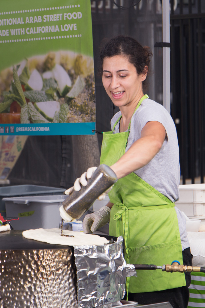 Reem working the saj, pouring some delicious za'atar sauce on the baking man'oushe