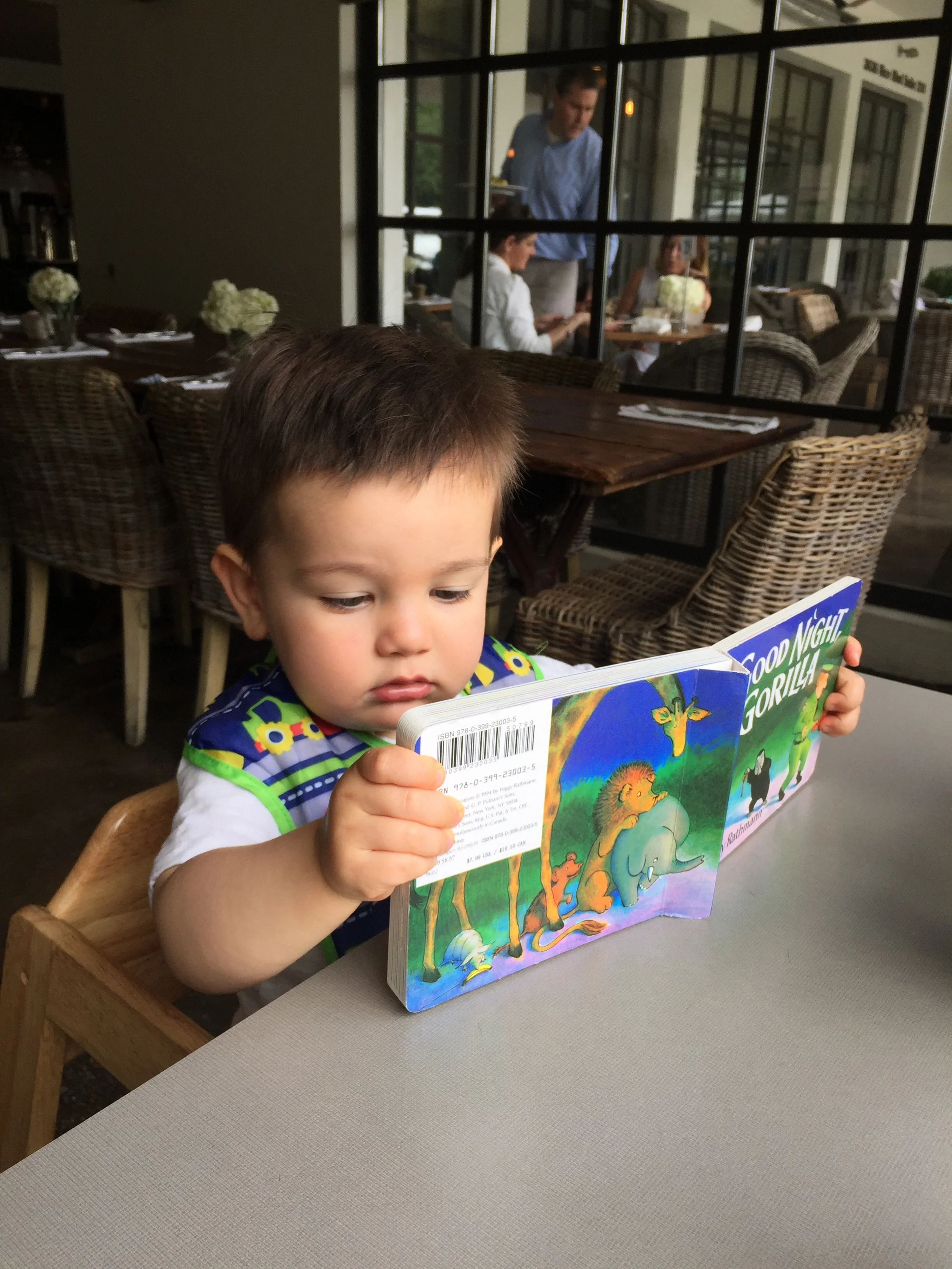 Keeping up on his reading during a lunch date with mom