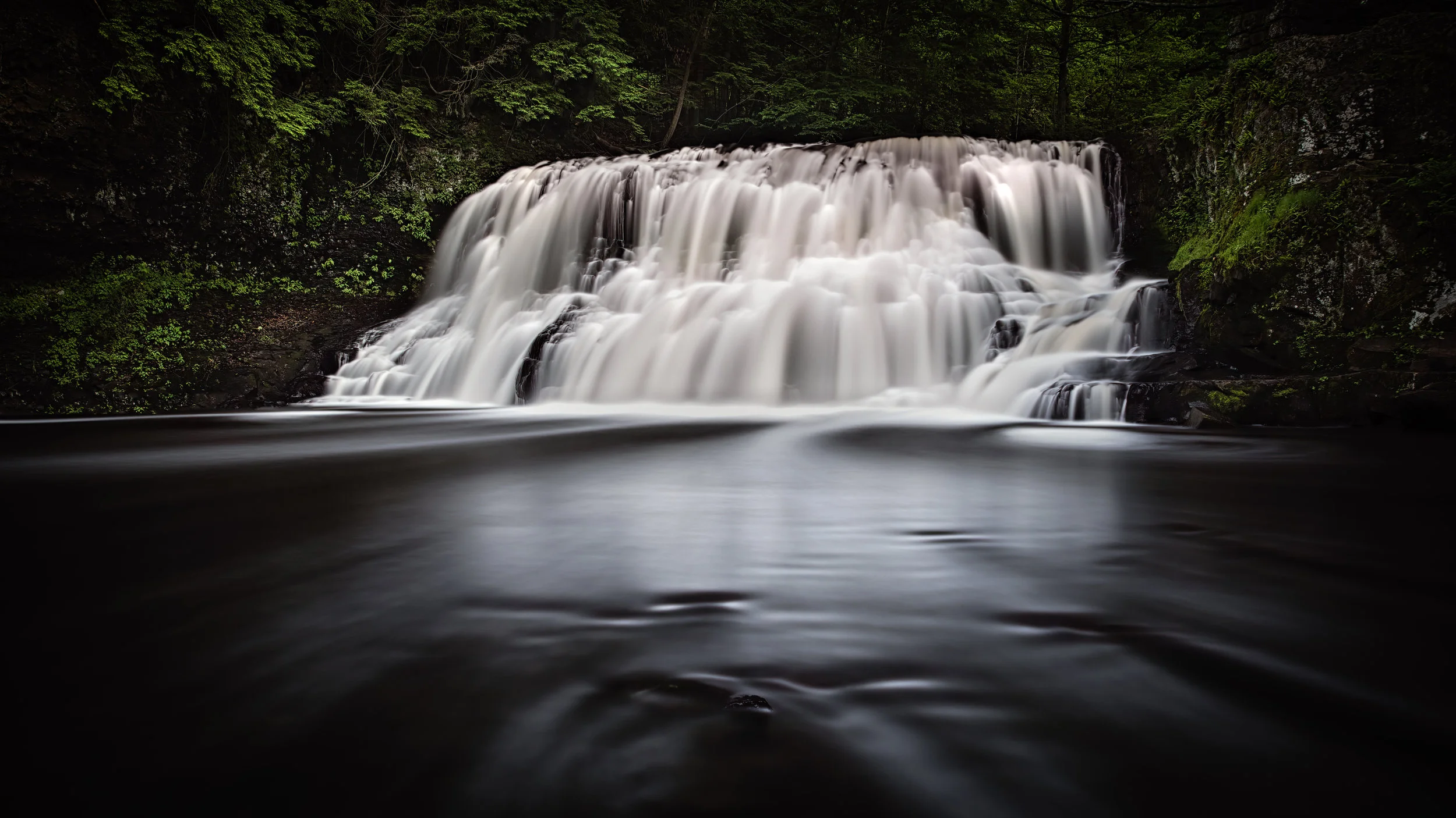 Head on, rocks in the middle with water going on either side of me. Trees blended in from a normal shutter speed for stillness.
