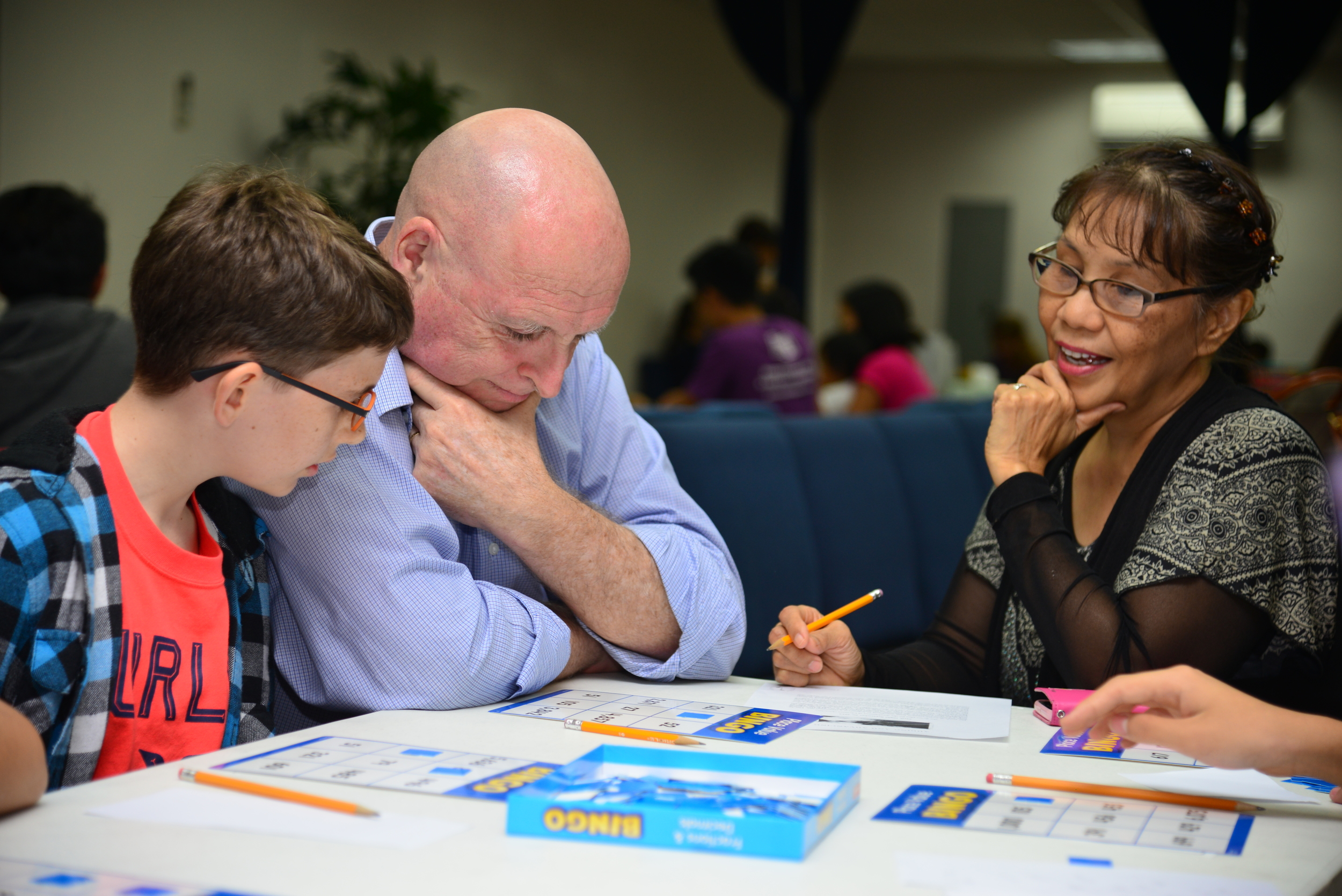Josiah Roberts actively engaged in a game of math bingo with parents Jerry and Nellie Joy.